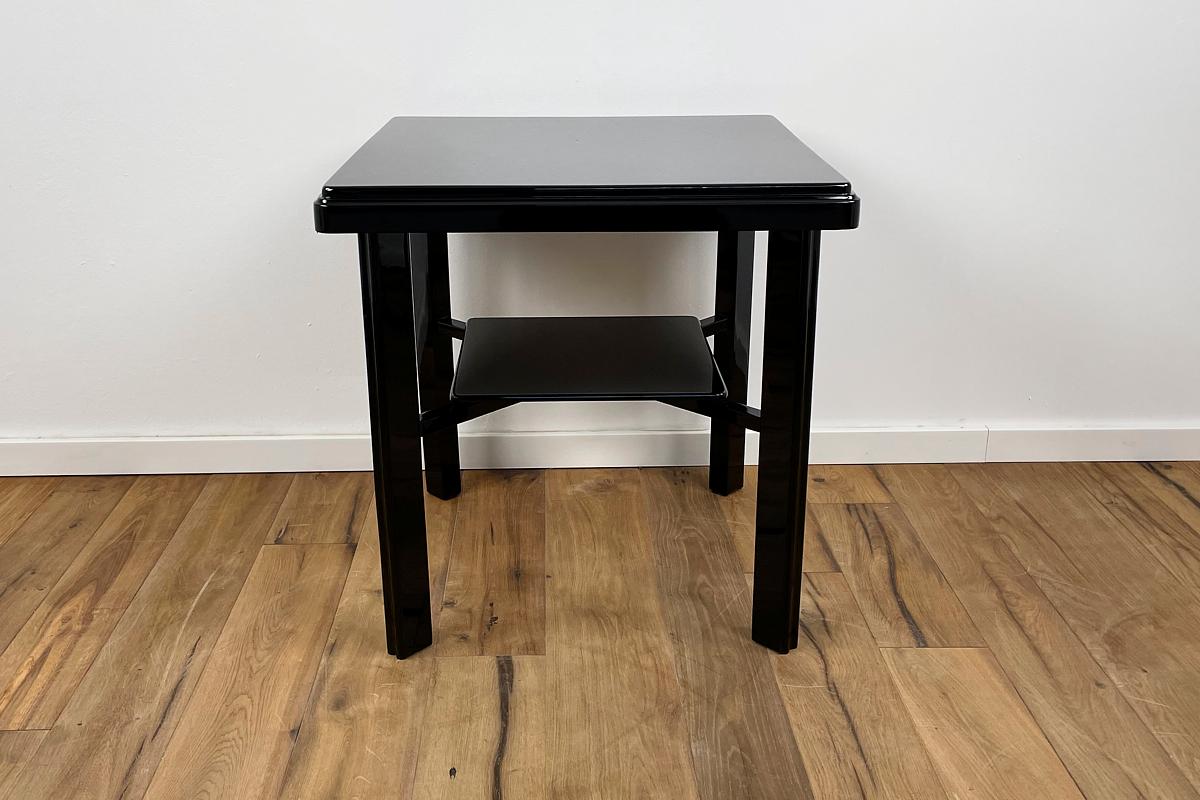 Side table in Art Deco style that convinces with its classic elegance. The clear shapes and lines make this table a perfect companion for almost all seating furniture. Especially the crossed frame under the lower shelf in combination with the thin