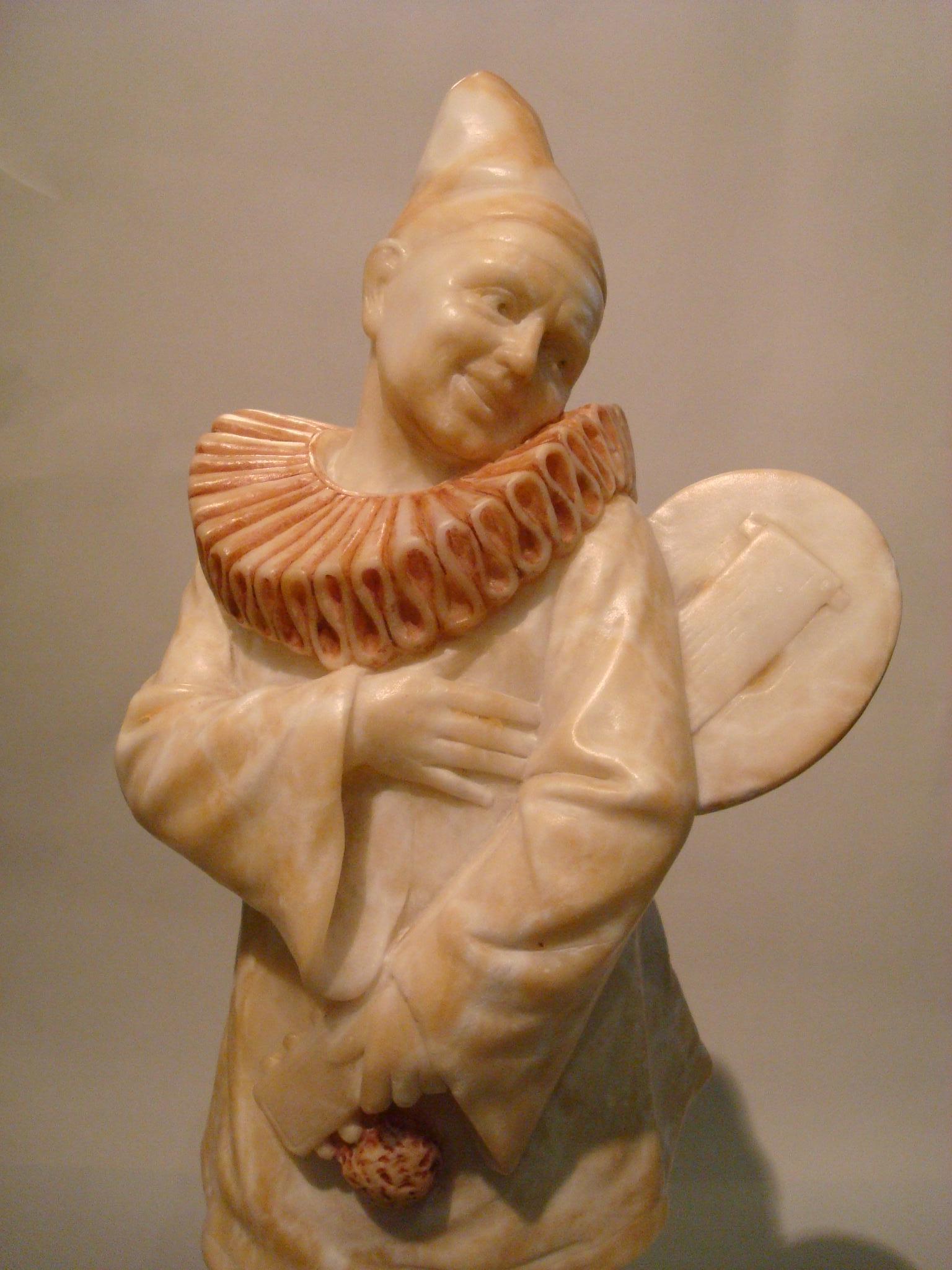Art Deco signed Alabaster pierrot clown sculpture.
Pierrot sculpture playing the mandolin.

The figure is signed, but i cannot read what it says.
 