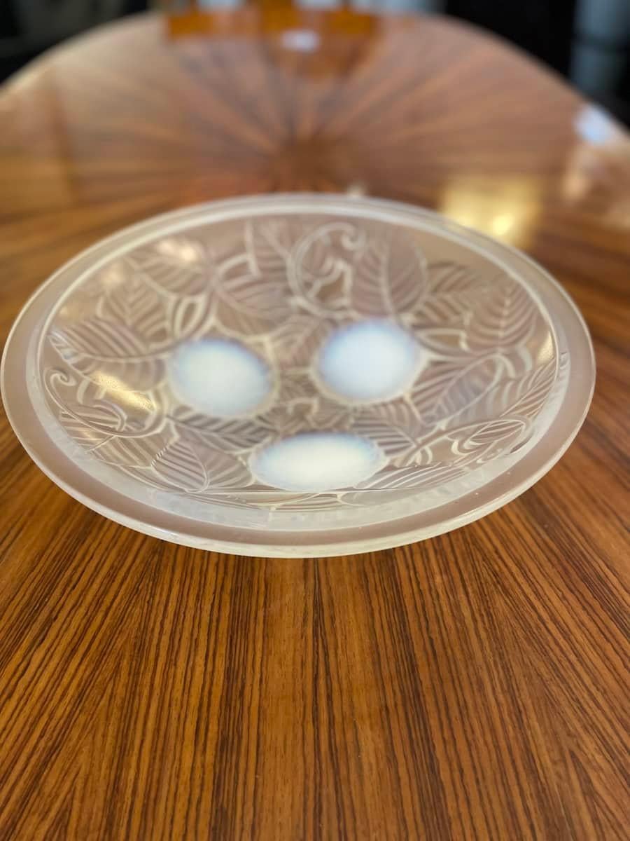 Round Art Deco-style valet tray featuring intricate engraved details of leaves and branches. The tray rests on three rounded glass supports.
Dimensions: diameter 35 cm, height 9.5 cm.

Price INCLUDES the costs for any packaging and crates needed to