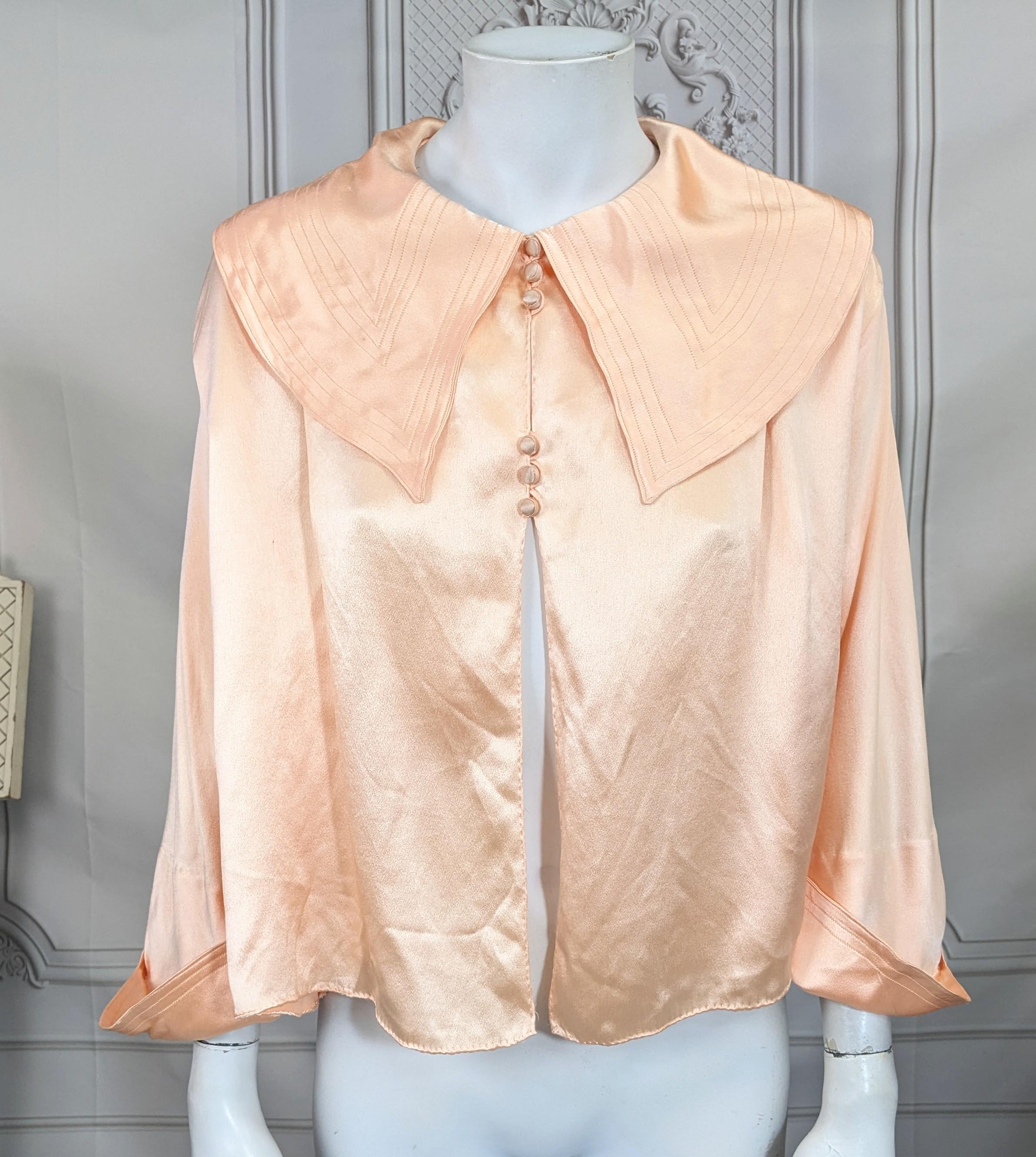 Chaqueta de cama Art Decó de satén de seda, vendida al por menor en Bonwit Teller NY en la década de 1930. Lujoso satén de seda con detalles de pespuntes en el cuello y los puños. Botones de seda forrados. Francia años 30. 
