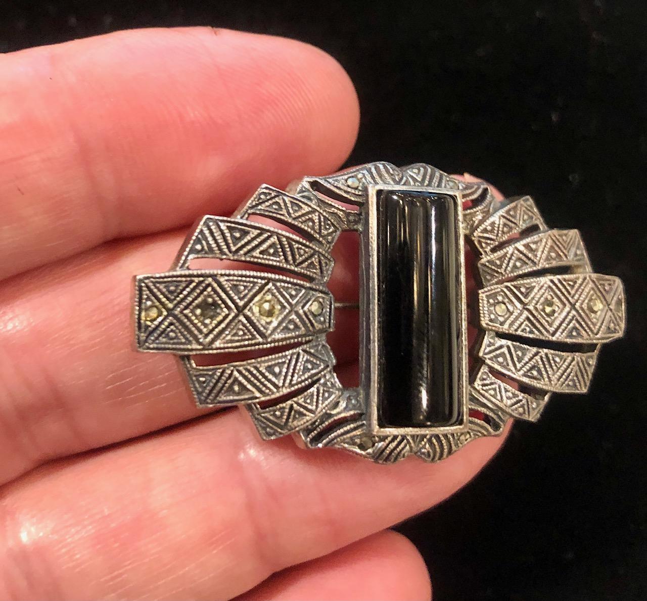 Art Deco silver Broach set with a large onyx in the middle and marcasites, English ca 1930's
One marcasite is missing, see pictures