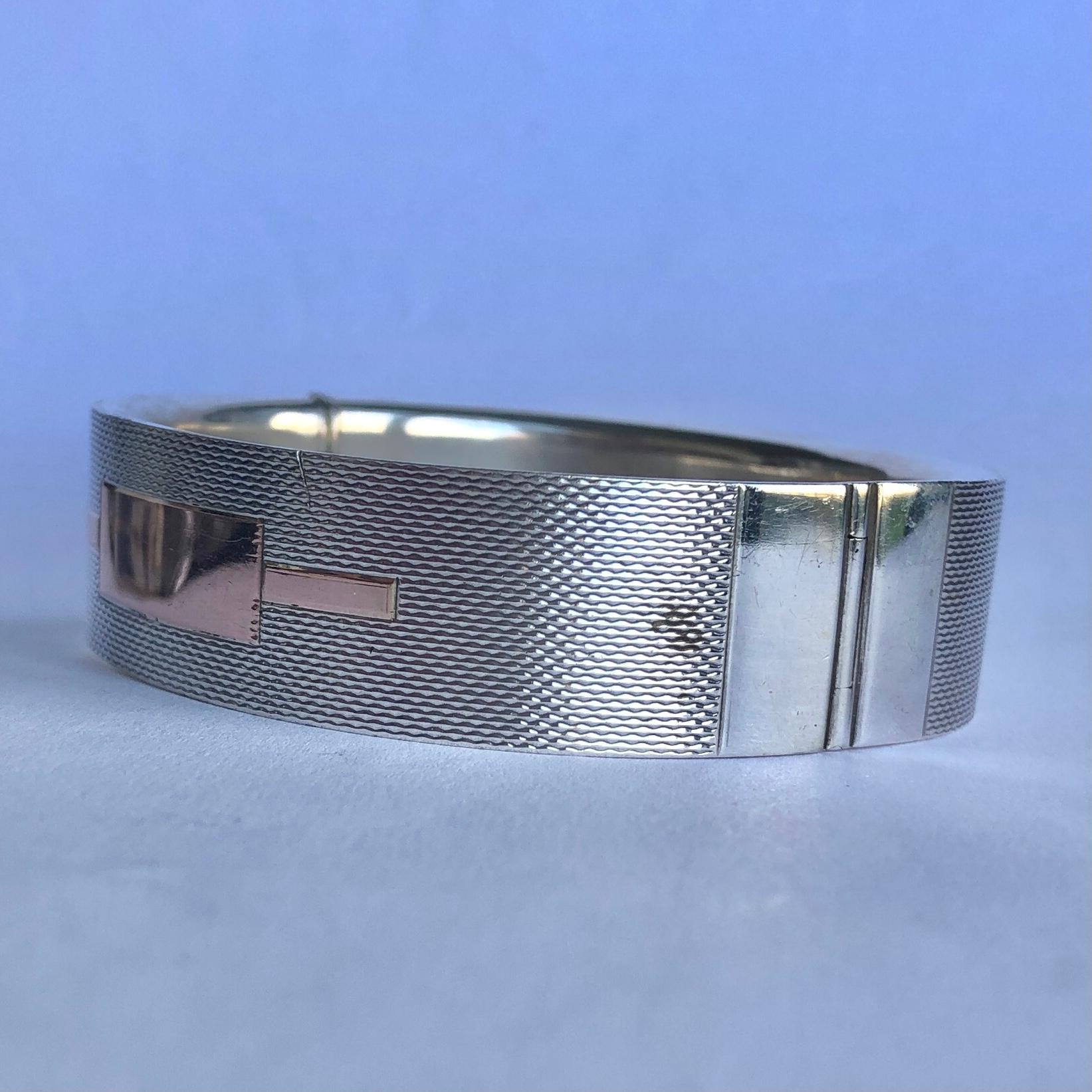 This gorgeous silver engine turned bangle has wonderful detail and the front has a rose gold overlay panel. Made in Birmingham, England. 

Inner Diameter: 55mm
Bangle Width: 16mm 

Weight: 29.2g