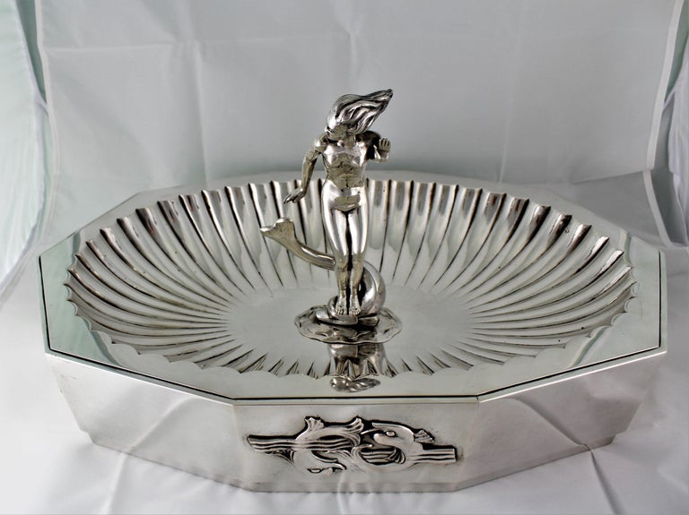Arrigo Finzi Art Deco centerpiece - Design By Futurist Architect Sant'Elia Antonio
Milan 1938 - 1943
Wonderful silver centerpiece Fountain like and octagon shaped embossed by hand.
In the middle a sculpture of a woman standing on dolphin (she