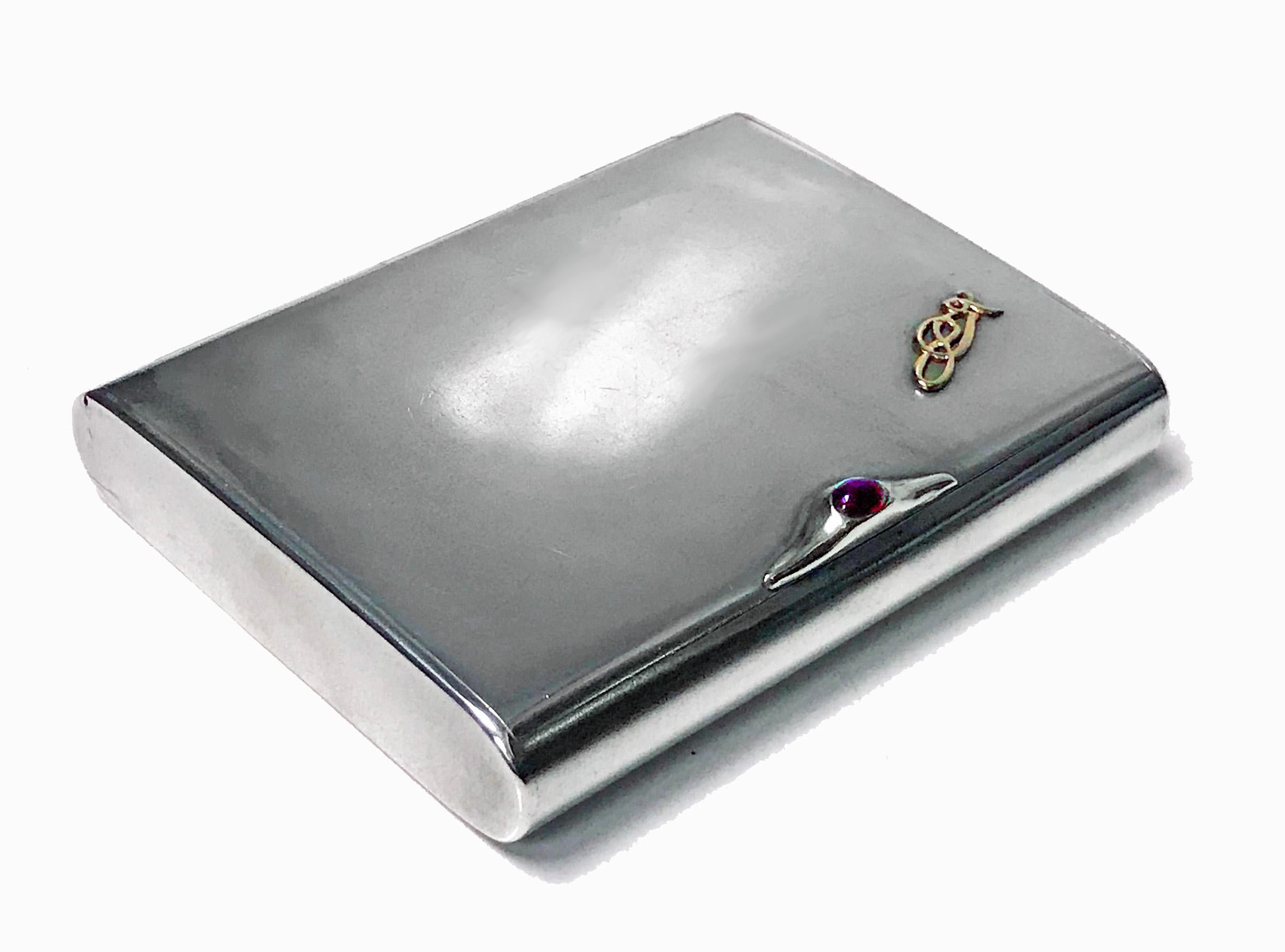 Art Deco silver cigarette case box, Estonia, circa 1925. Plain, flush hinge, cabochon red garnet thumb piece, gilded interior. No monograms, gold (tested) intertwined nouveau celtic insignia applied at one cornice, original patina, extremely light