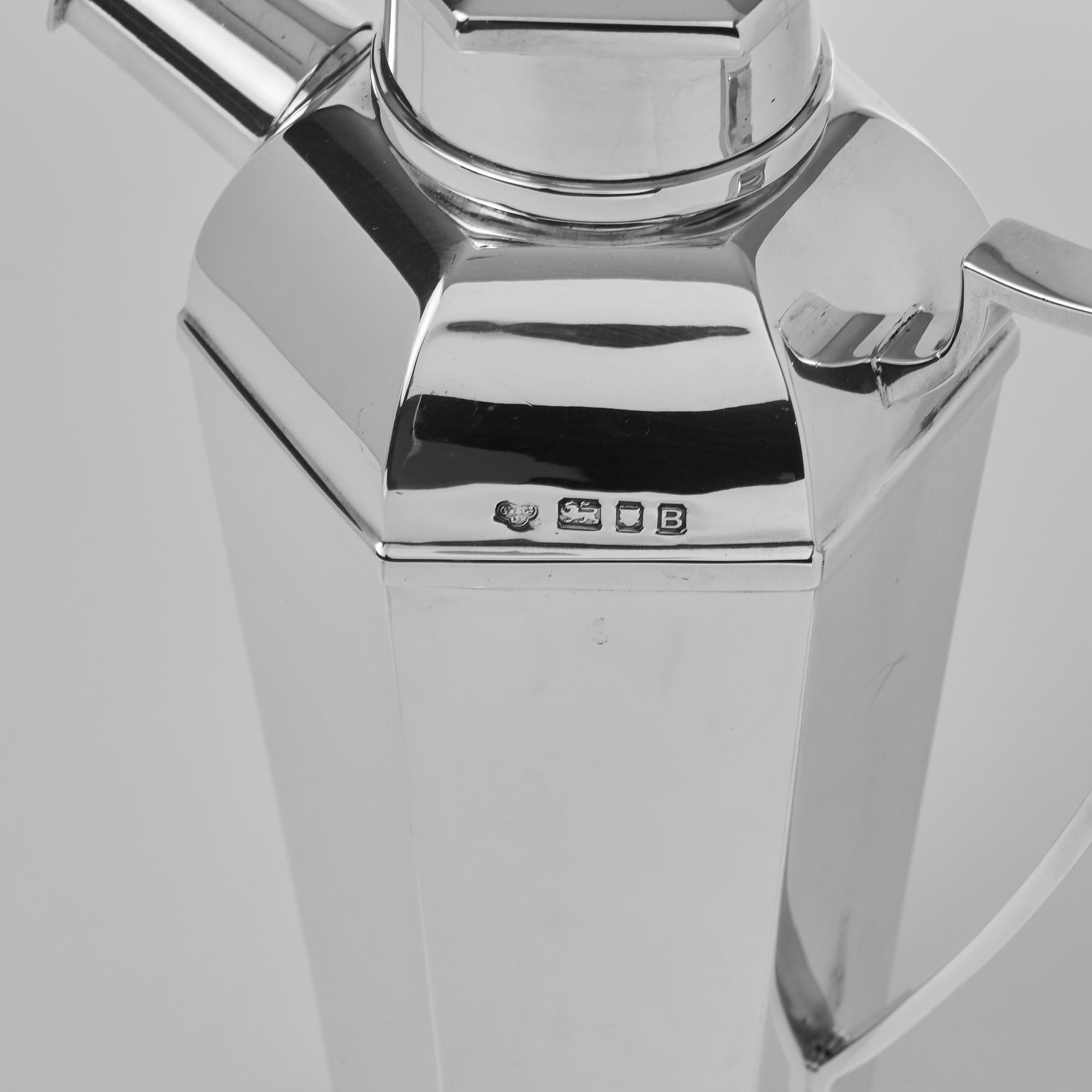 Stylish and very good quality Art Deco silver cocktail Shaker with a tapering hexagonal body, typical of the Art Deco era, and removable lid. This unusual example has a side handle and spout, reminiscent of a stylised fire extinguisher.

Weight 21