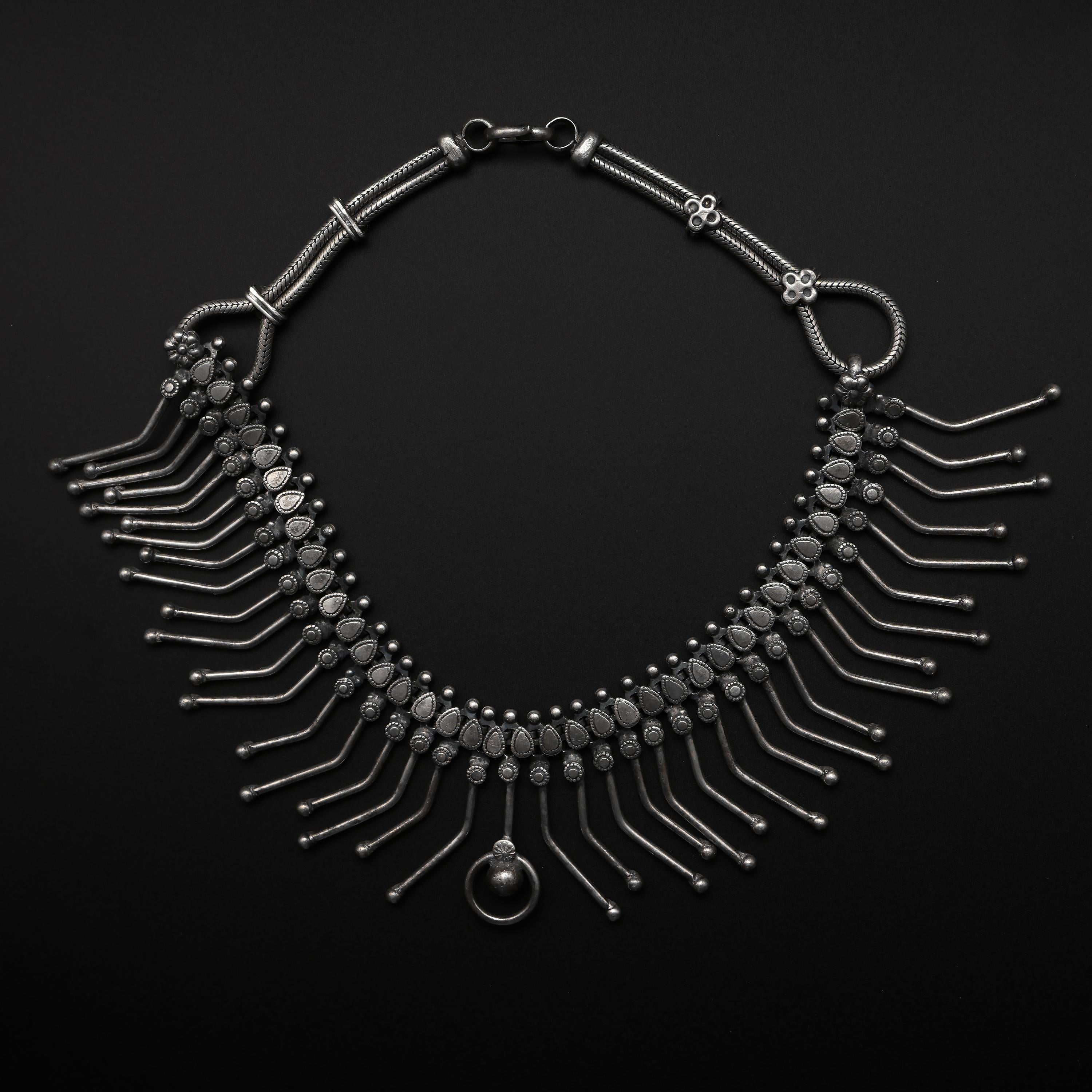 A large, dramatic statement necklace rendered in sterling silver and dating to the Art Deco era.  A lavish amount of silver was used in creating this piece: 115.19 grams; that’s a quarter of a pound of sterling silver.  

Each component of this