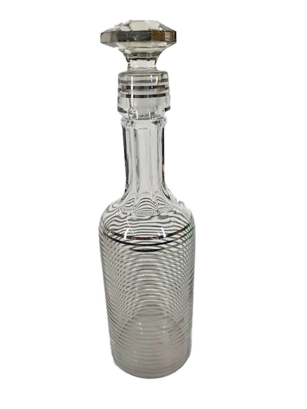 Art Deco silver decorated back bar bottle and stopper, the bottle with alternating clear and silver bands from the shoulder to the base and an undecorated faceted neck with bands at the collar, the eight-sided mushroom stopper is silvered along the