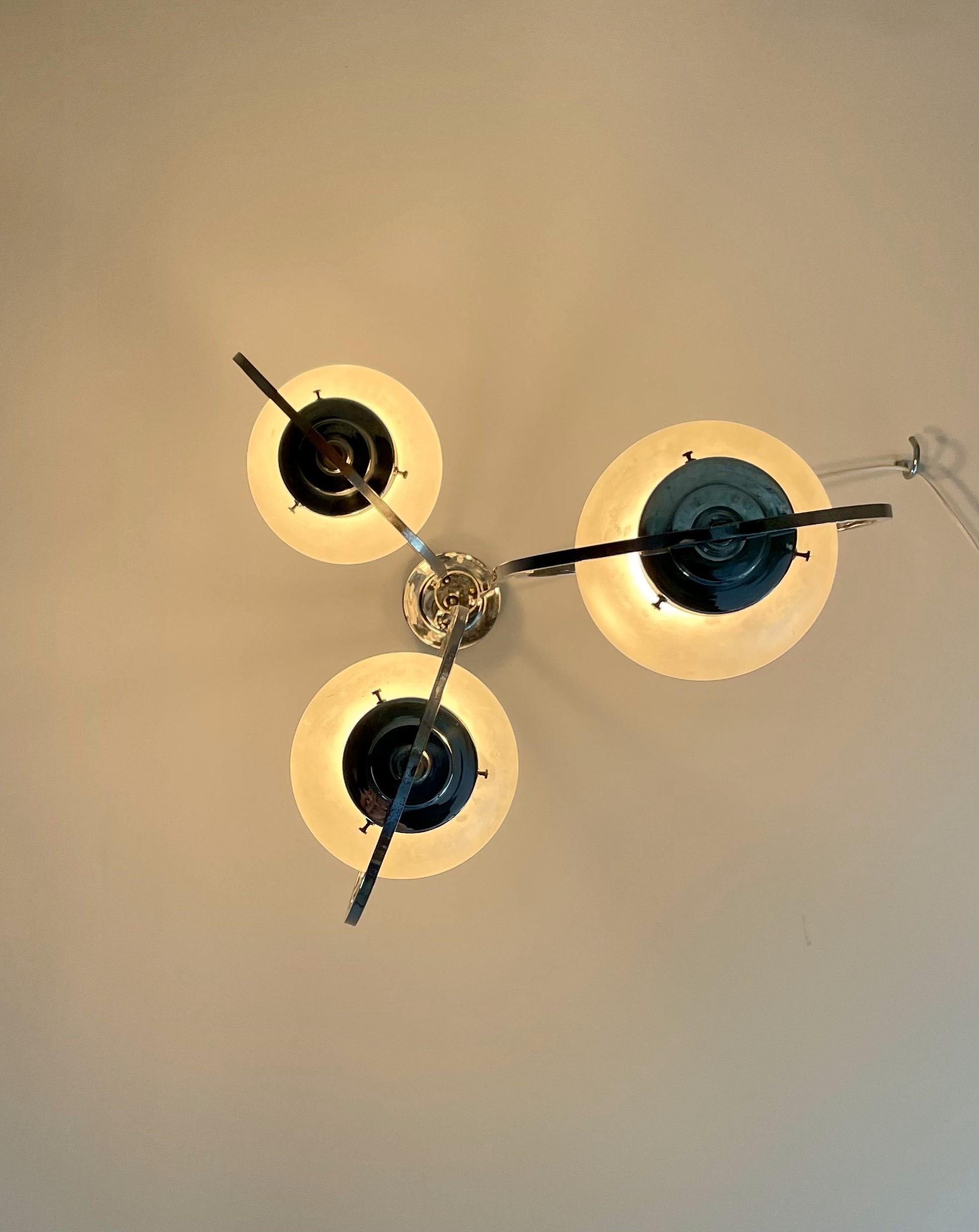 A striking Art Deco silver lamp featuring three spherical glass shades, exuding vintage elegance and geometric style. Perfect for adding a touch of classic sophistication to any modern space.