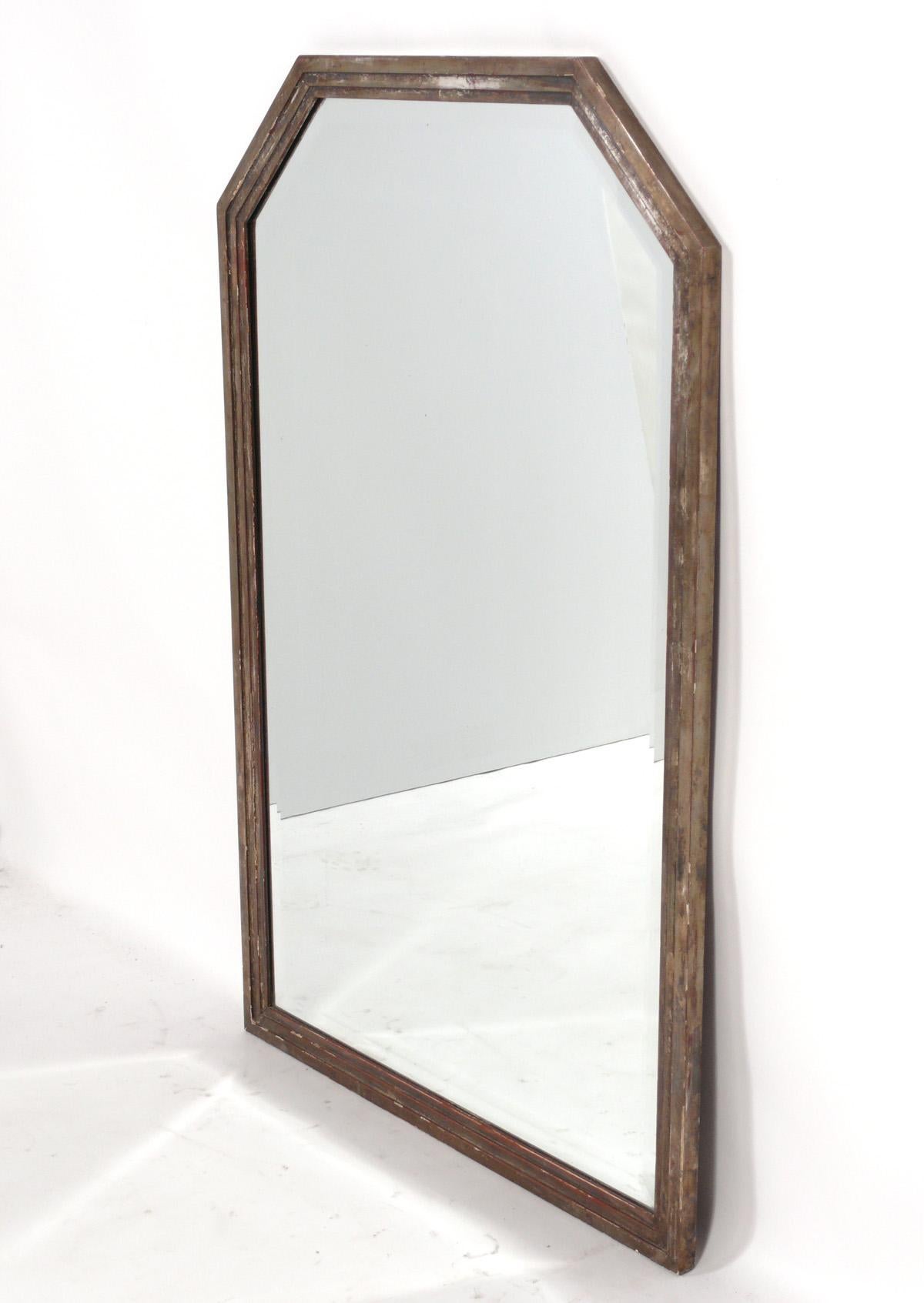 Art Deco Mirror in Wonderful Distressed Silver Leaf Finish, American, circa 1930s. Elegant Art Deco stepped design and wonderful distressed silver leaf finish, beautifully revealing the deep Chinese red color bole or underlayer. It measures an