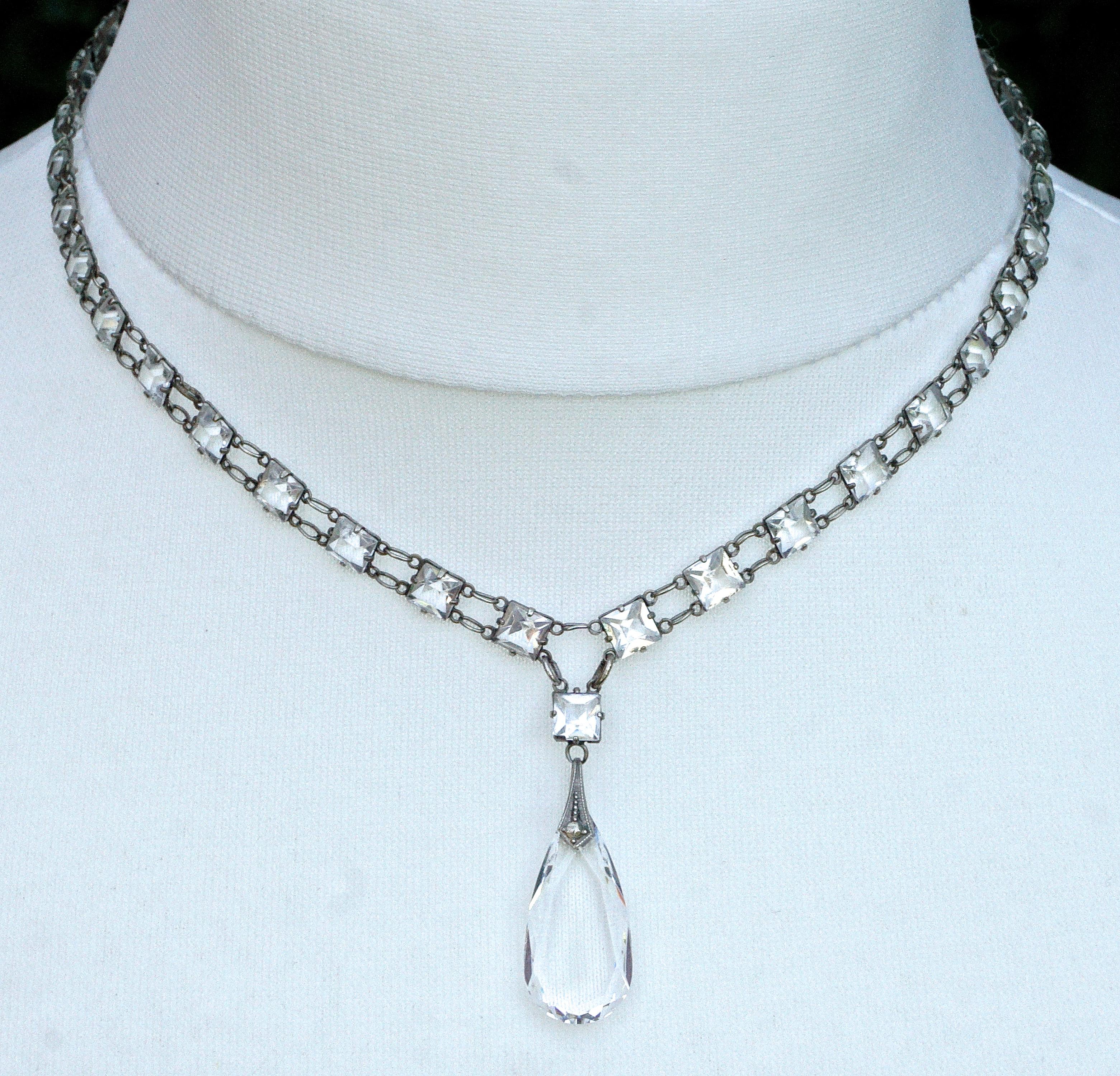 Art Deco silver tone link chain necklace featuring beautiful square clear glass crystals in open back settings, and a lovely faceted teardrop pendant. The spring bolt clasp is sterling silver. The faceted crystals are raised at the front and pointed