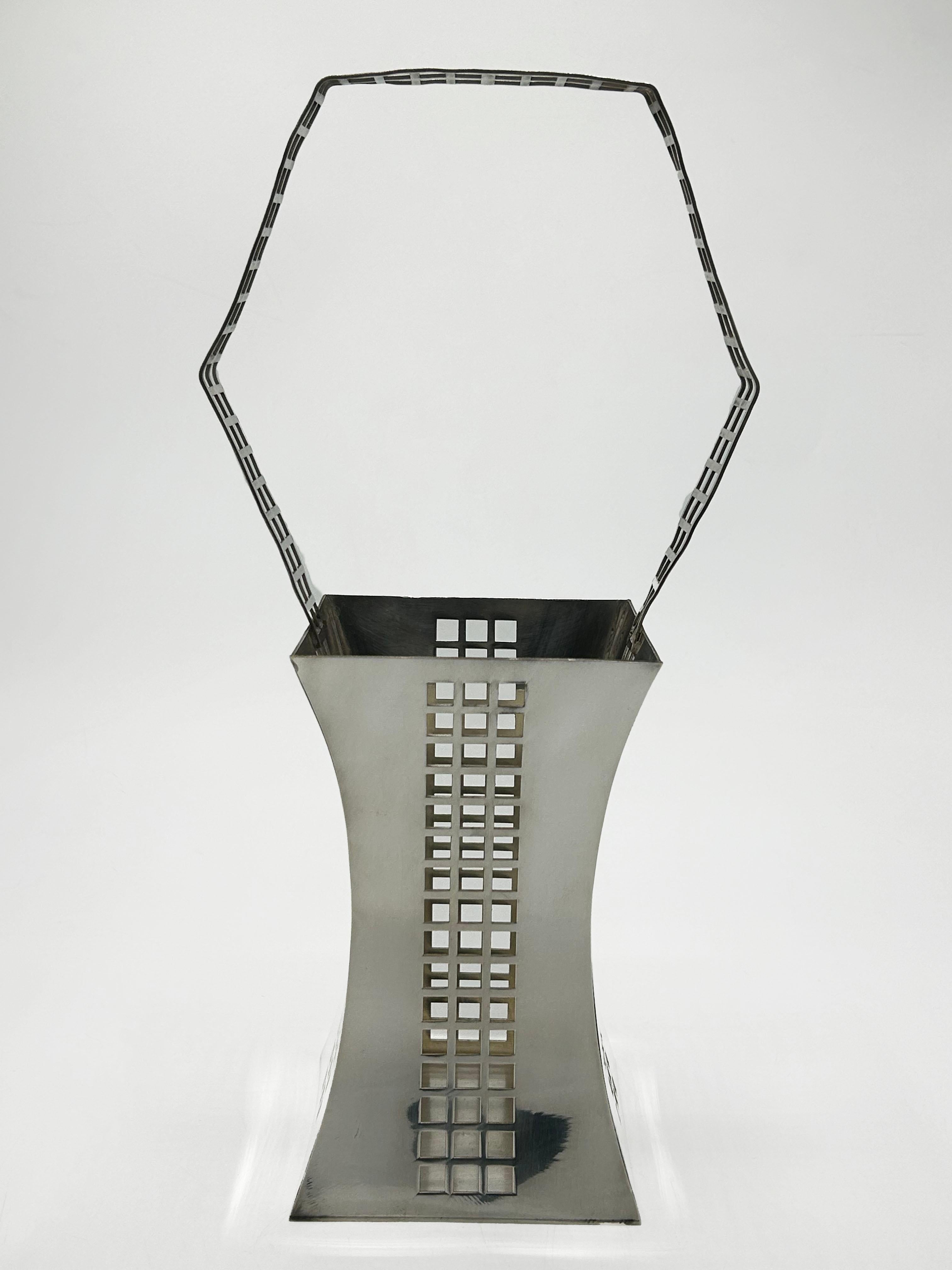 Art Deco Silver-Plated Basket by Josef Hoffmann
This decorative basket by Josef Hoffmann features an elegant and distinctive silhouette, with a body that widens at the base and mouth, narrowing sharply in the center, creating a dynamic, concave