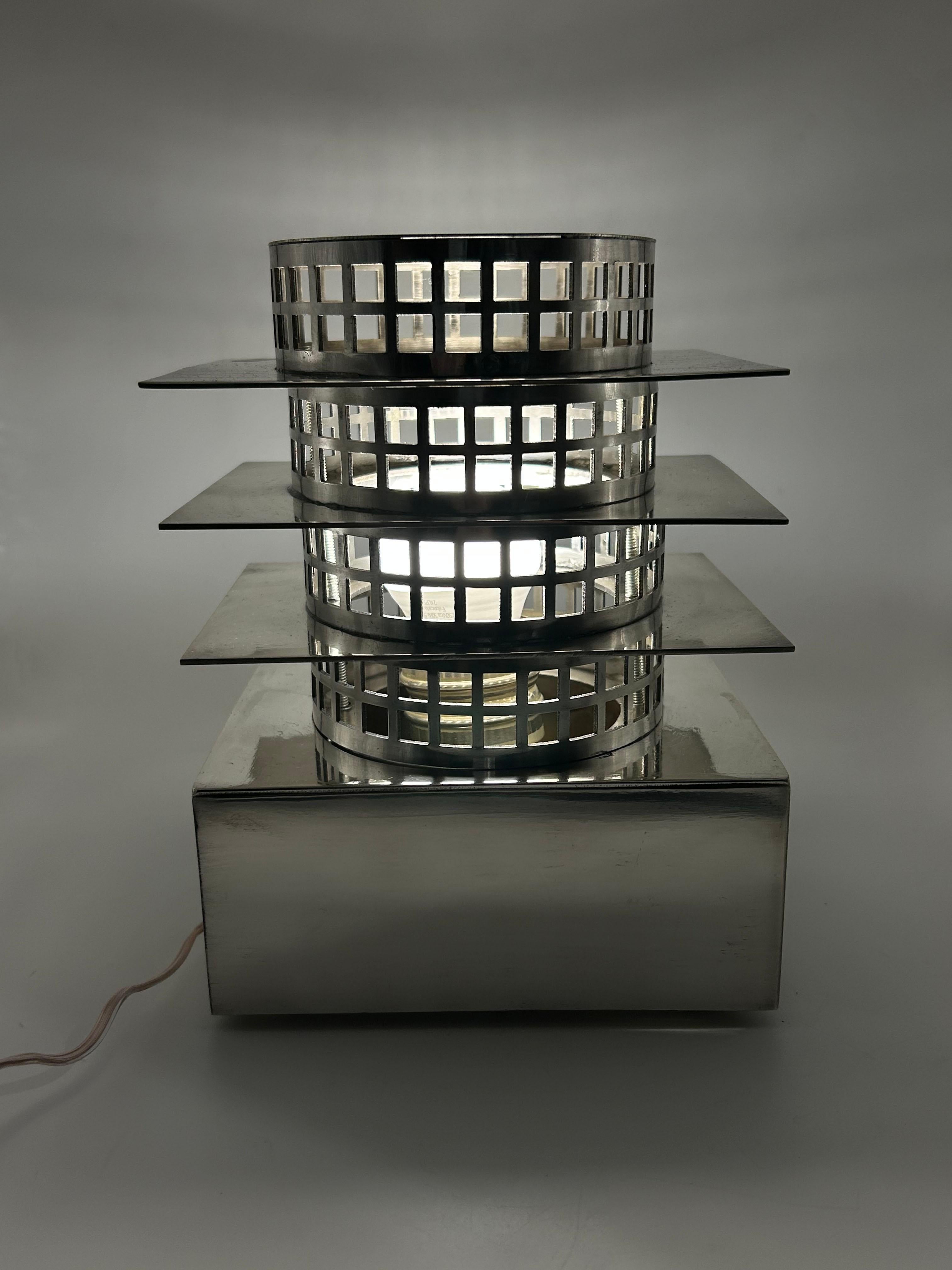 Lampada Art Deco in metallo placcato argento di Maison Desny
Questa lampada da tavolo in metallo argentato, attribuita a Desny Paris, è realizzata in Francia ed evoca lo stile Art Deco. Presenta una solida base rettangolare in metallo lucido e