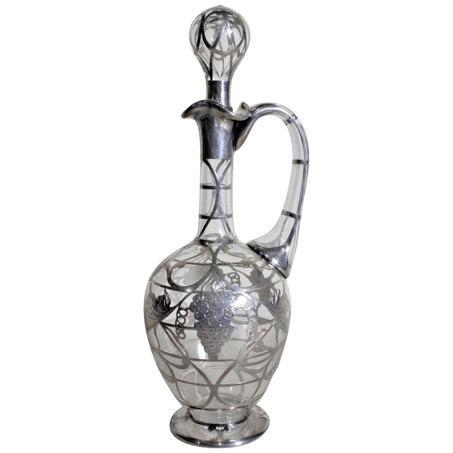 https://a.1stdibscdn.com/art-deco-silver-overlay-clear-glass-port-or-sherry-decanter-with-grapes-leaves-for-sale/1121189/f_230048321616242657444/23004832_master.jpg?width=1500