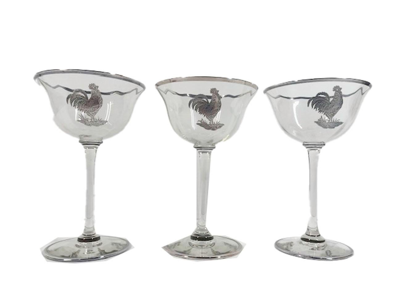 Eight Art Deco martini glasses having optical ribbed bowls raised on tall stems, decorated with a silver overlay rooster and a silver band at the bowl and foot rims.