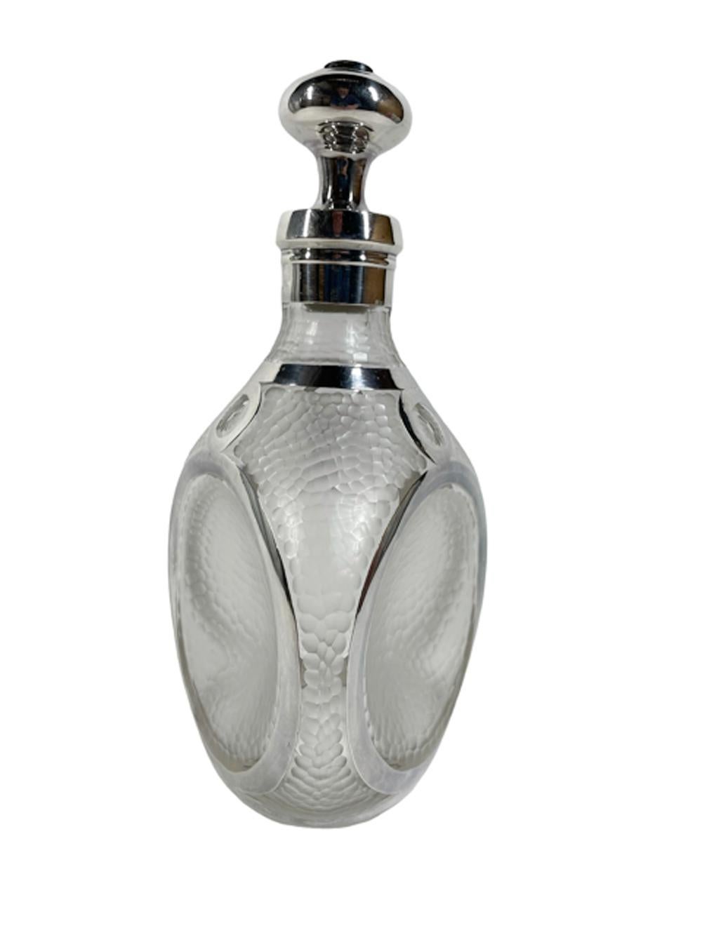 Art Deco silver overlay pinch decanter having a 'hammered' frosted surface, dimpled on each of the three sides with a wide silver band surrounding the dimple and attached to a ring at the neck by smaller circles enclosing cut flowerheads. The collar