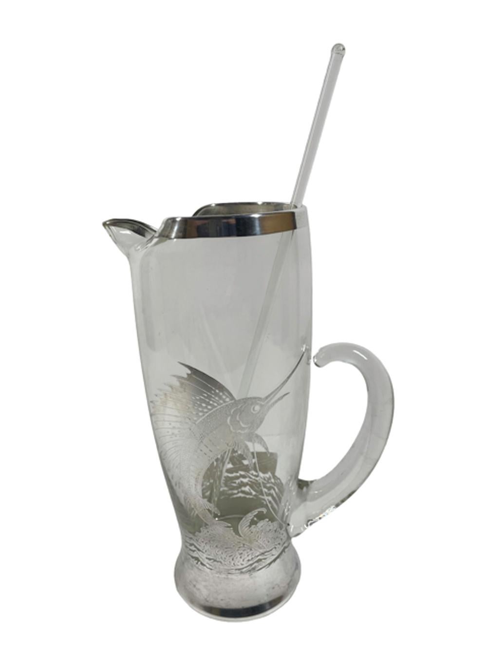 Art Deco silver overlay cocktail pitcher with glass stir rod and 8 tumblers. The pitcher and tumblers all decorated in sterling overlay with a leaping sailfish / marlin on the front and two men fishing from a dory on the back, all connected by a