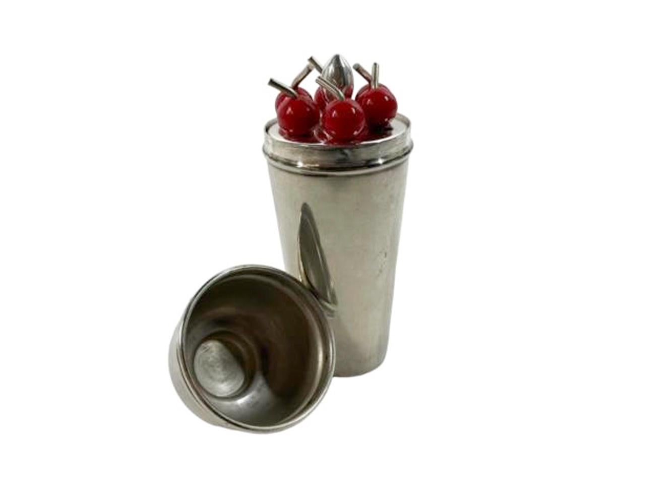 Art Deco silver plate cocktail pick / spirit measure set. A cocktail shaker form jigger containing a stand with 6 red Bakelite topped picks, the container top and base usable as measures. Marked on bottom 