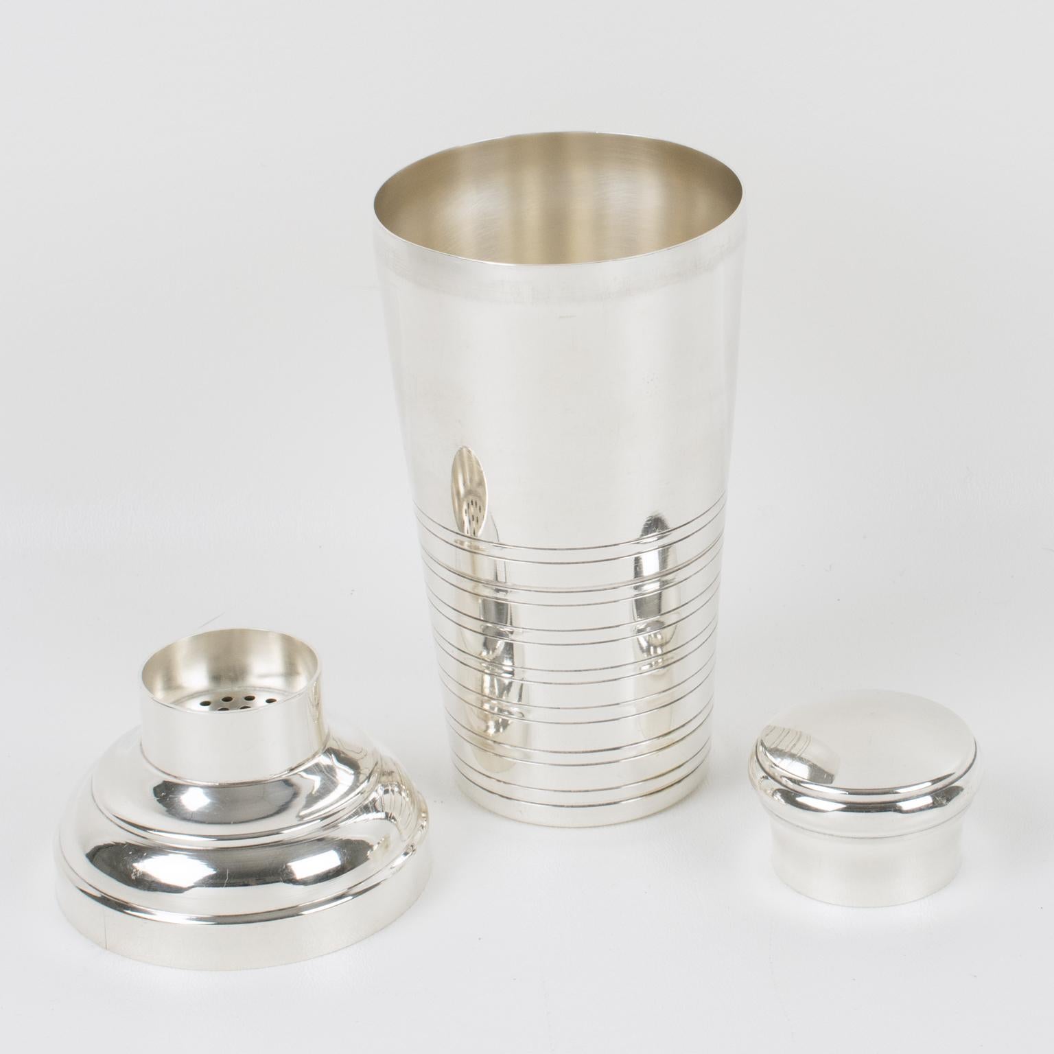 Lovely French Art Deco silver plate cylindrical cocktail or Martini shaker by silversmith Capargent, Paris. Three-sectioned designed cocktail shaker with removable cap and strainer. Geometric shape with typical Deco design around the base. Marked
