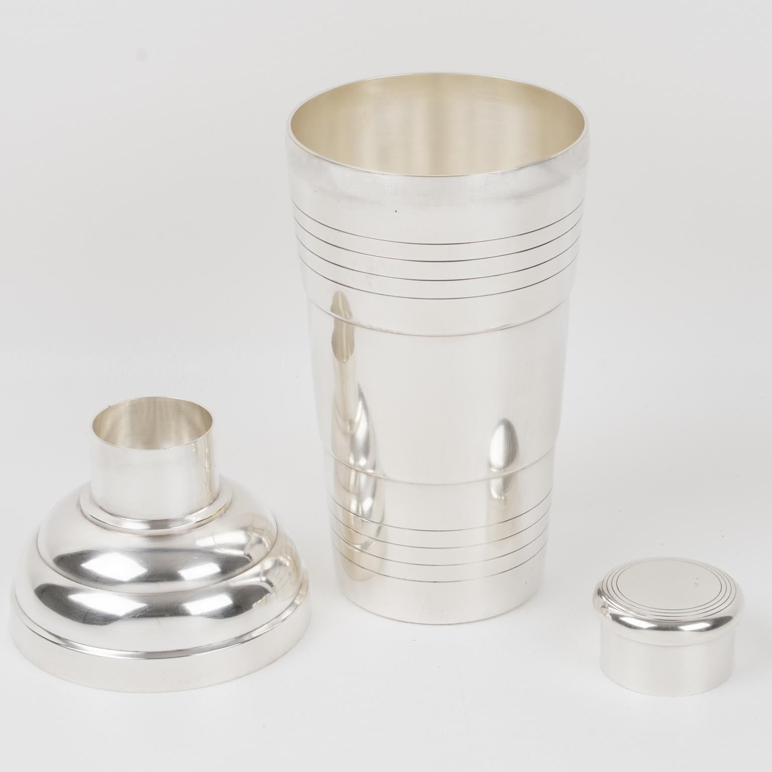 Lovely French Art Deco silver plate cylindrical cocktail or Martini shaker by silversmith Demarquay, Paris. Three-sectioned designed cocktail shaker with removable cap and strainer. Geometric shape with typical Deco design around the container.