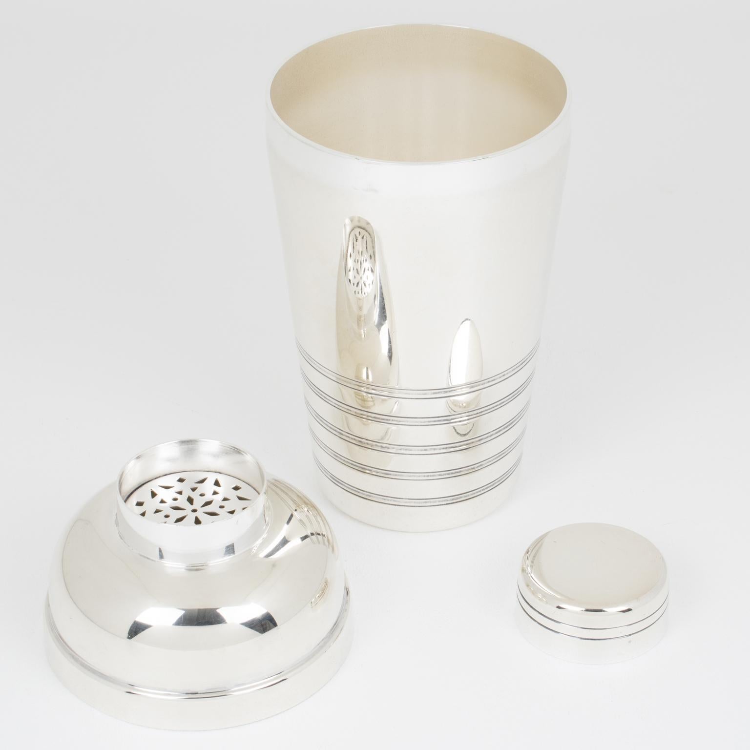 This elegant French Art Deco silver plate cylindrical cocktail or Martini shaker was designed by silversmith Maison Vessiere, Paris. The three-sectioned cocktail shaker has a removable cap and strainer. The piece features a lovely geometric shape