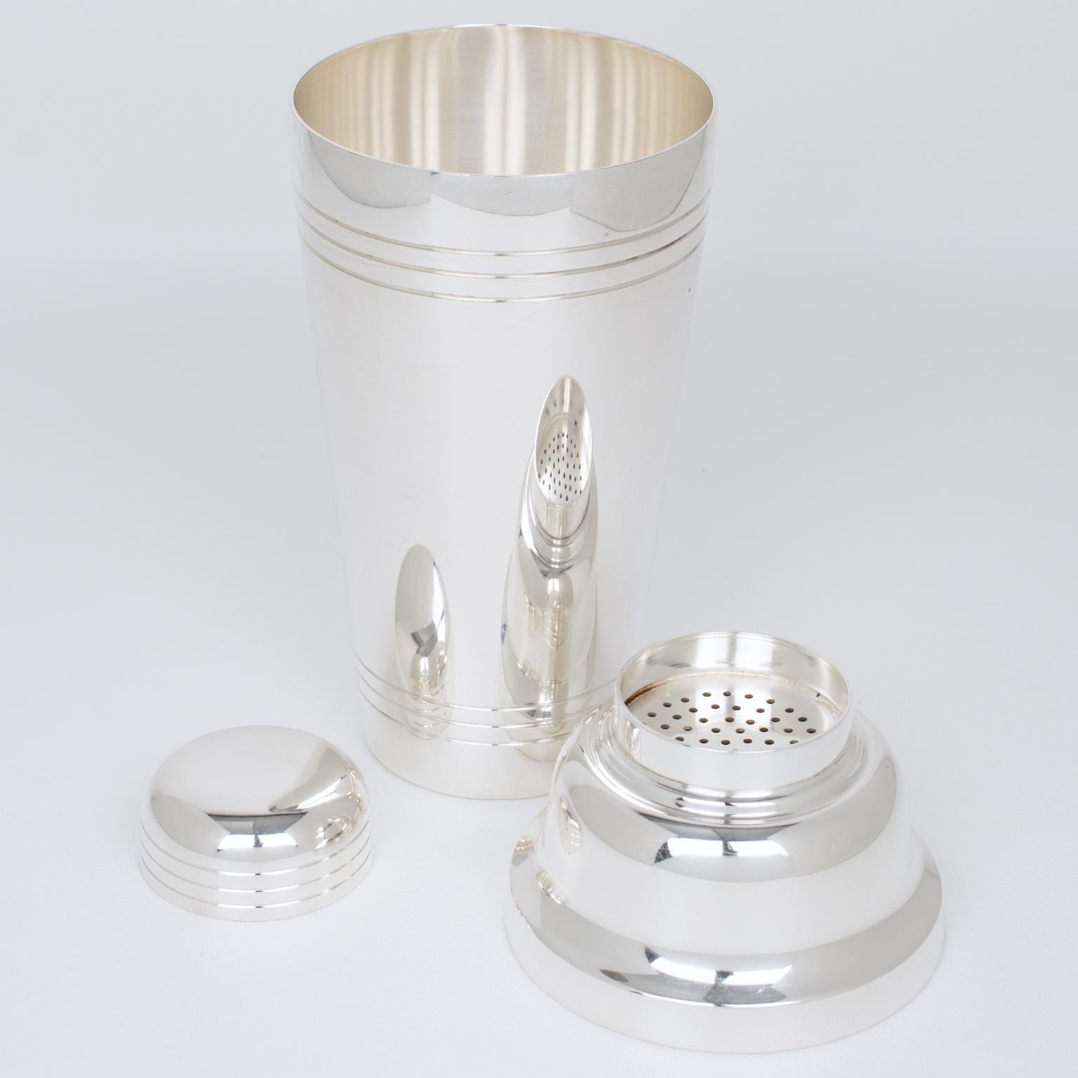 This elegant Art Deco silver plate cylindrical cocktail or Martini shaker was crafted by French silversmith Roux & Marquiand, Paris in the 1940s. This large, tall three-sectioned cocktail shaker has a removable cap and filter strainer. The bar