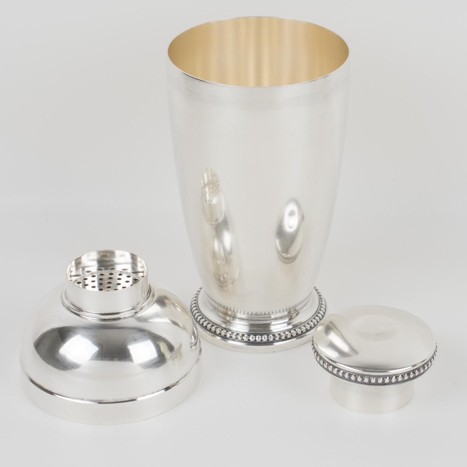 Élégant shaker cylindrique Art Déco en métal argenté de l'orfèvre Saint Médard:: Paris. Shaker à cocktail en trois parties:: avec bouchon et passoire amovibles. Joli design Art Déco avec des perles géométriques biseautées tout autour de la base et