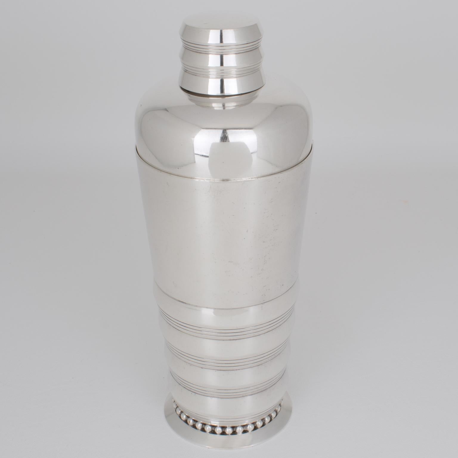 French silversmith Memery and Cie, Villeurbanne, France, crafted this lovely Art Deco silver plate cylindrical cocktail or Martini Shaker in the 1940s. The three-sectioned cocktail shaker has a removable cap and filter strainer. This barware