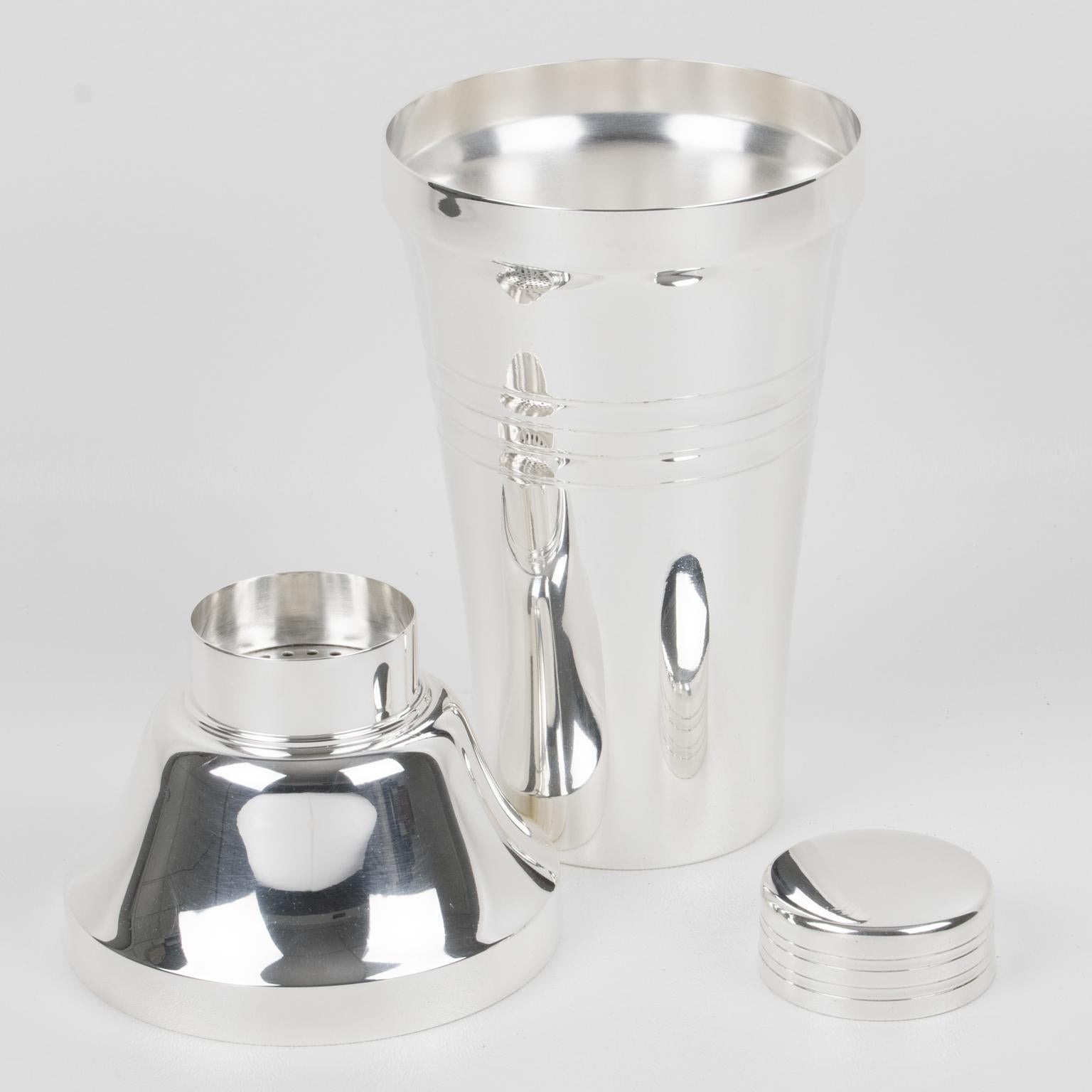 Silversmith Saint Medard, Paris, crafted this stylish Art Deco silver plate cylindrical cocktail or Martini shaker in the 1940s. The three-sectioned cocktail shaker has a removable cap and filter strainer. The piece boasts a lovely Art Deco design