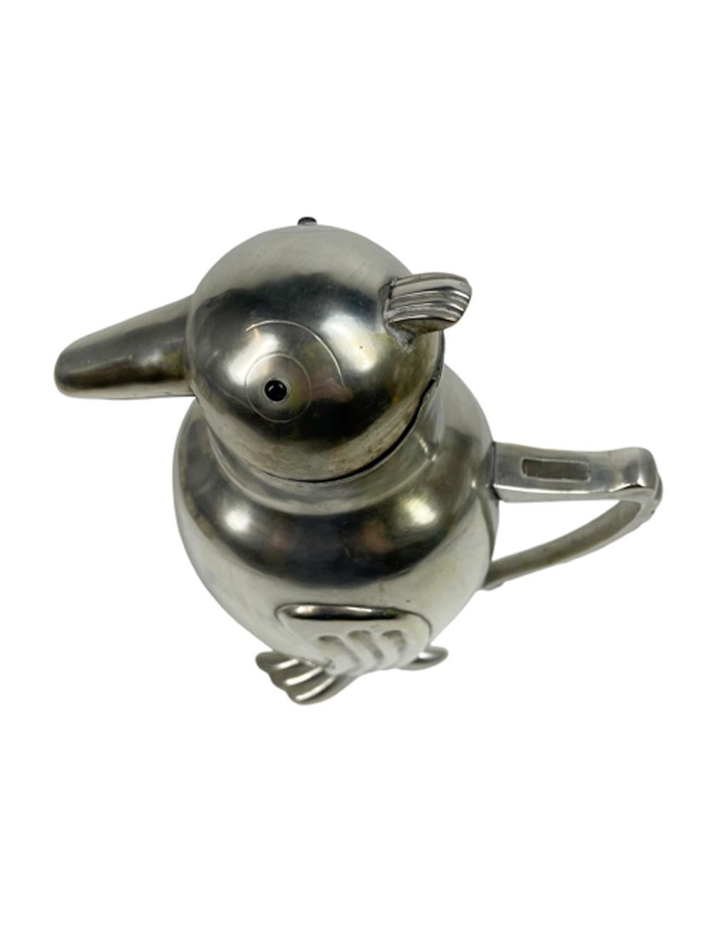 A hard to find Art Deco silver plated brass bar or water pitcher in the form a penguin with black glass eyes the hinged head lifts for filling and when tipped forward to pour the hinged beak opens for the liquid to pass.