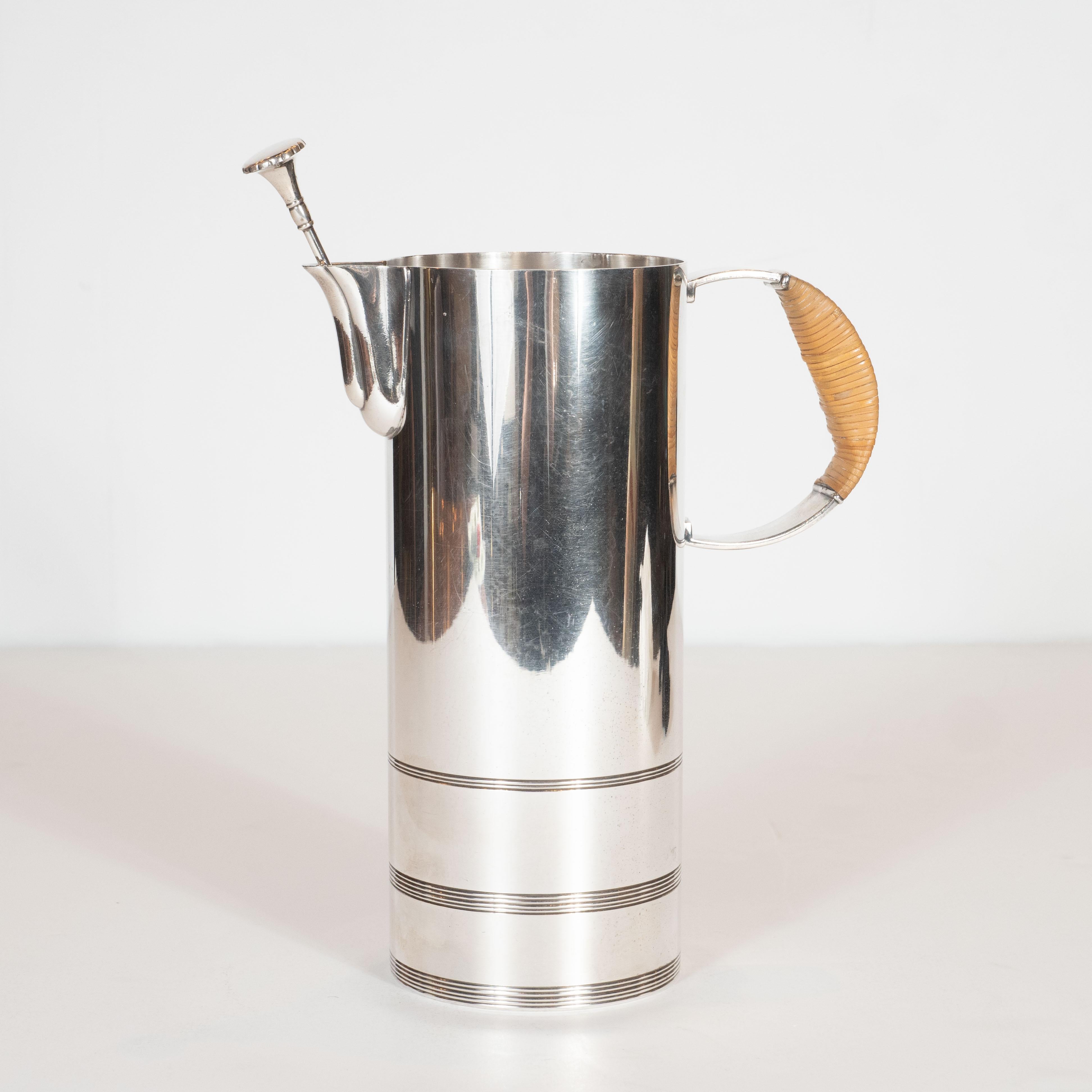 This stunning Art Deco cocktail pitcher was realized by the renowned architect, industrial designer and interior designer Lurelle Van Arsdale Guild in America, circa 1940. It features a cylindrical body with three sets of etched horizontal banding