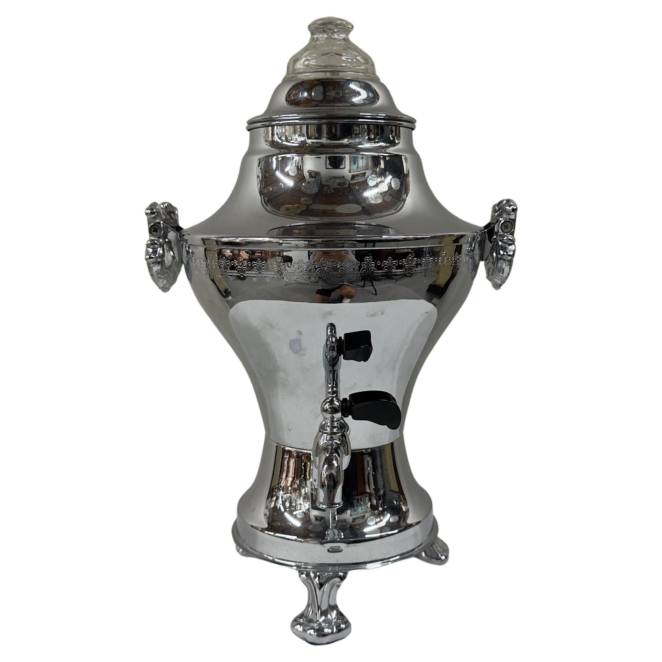 Diese  Der versilberte Art-Déco-Samowar steht für Eleganz und zeitlose Handwerkskunst. Seine anmutige, bauchige Form ist mit raffinierten Details verziert und spiegelt eine raffinierte Ästhetik wider. Auf vier elegant geschwungenen Beinen stehend,