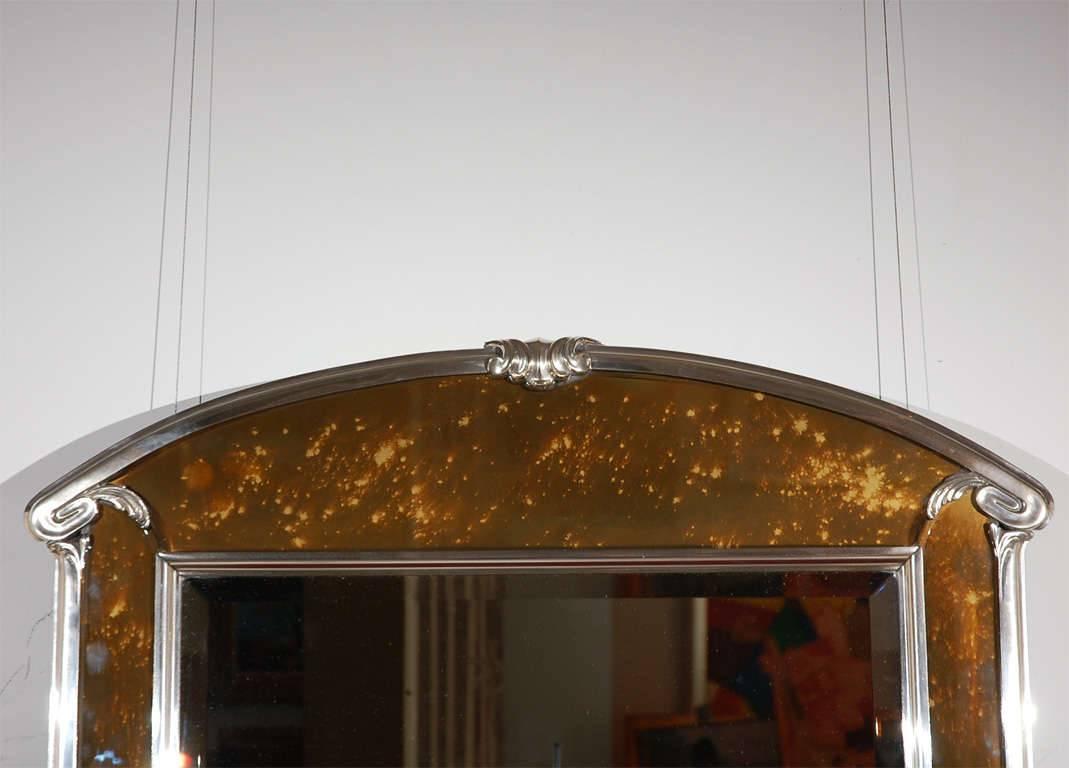 A fanciful Art Deco silver-plated bronze and tortoise spotted glass wall mirror. This exquisite mirror from the 1920s is a real stunner. Beautiful scroll and leaf details complete the look. This may have been a marquee frame from a theatre