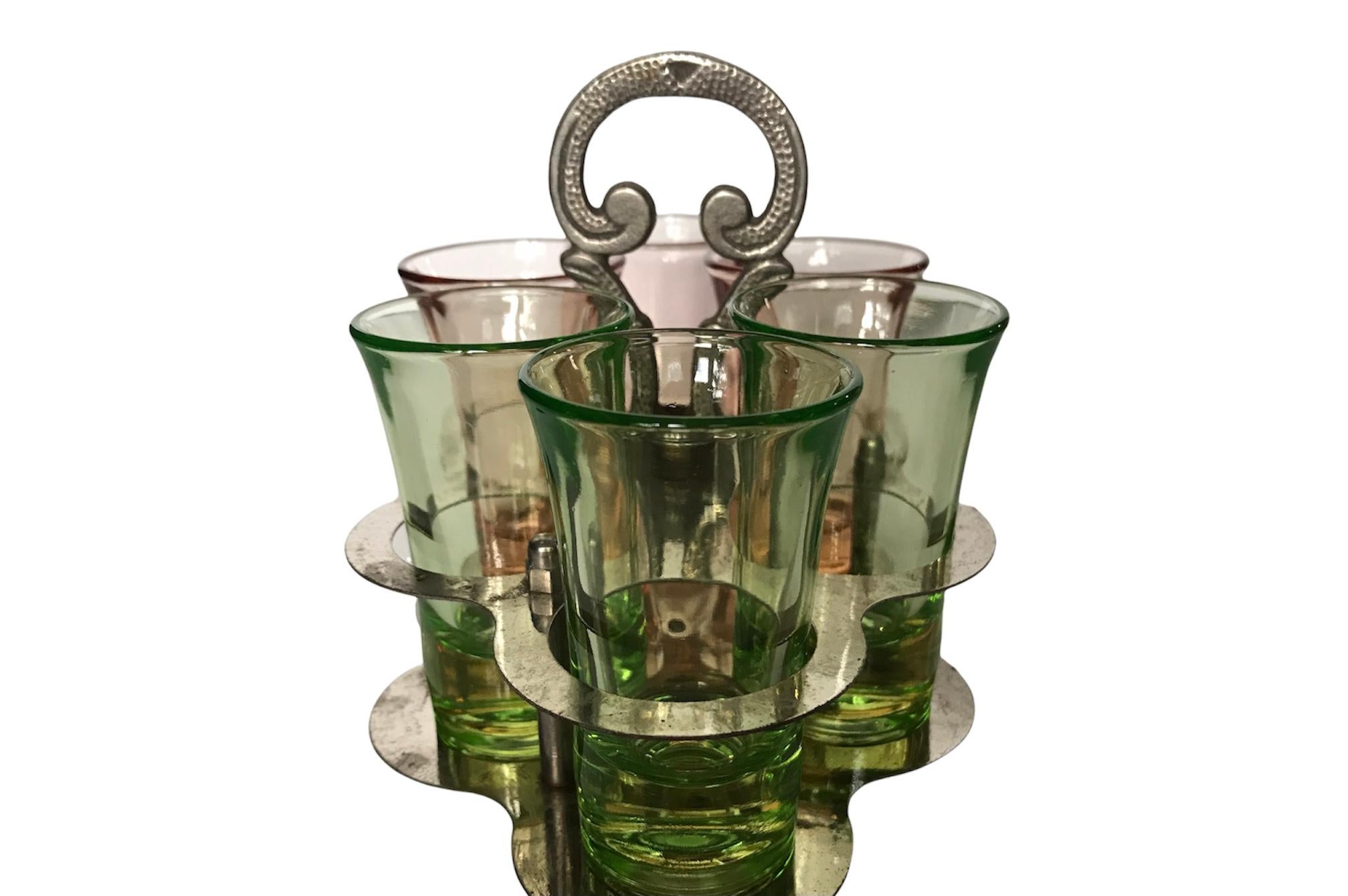 Rare find! such a unique set of cordial glasses kept in a silver-plated serving caddy. The silver-plated caddy offers a 6-hole holding station for the cordial glasses (3 pink and 3 green) with a handle that models a hand-hammered technique design.
