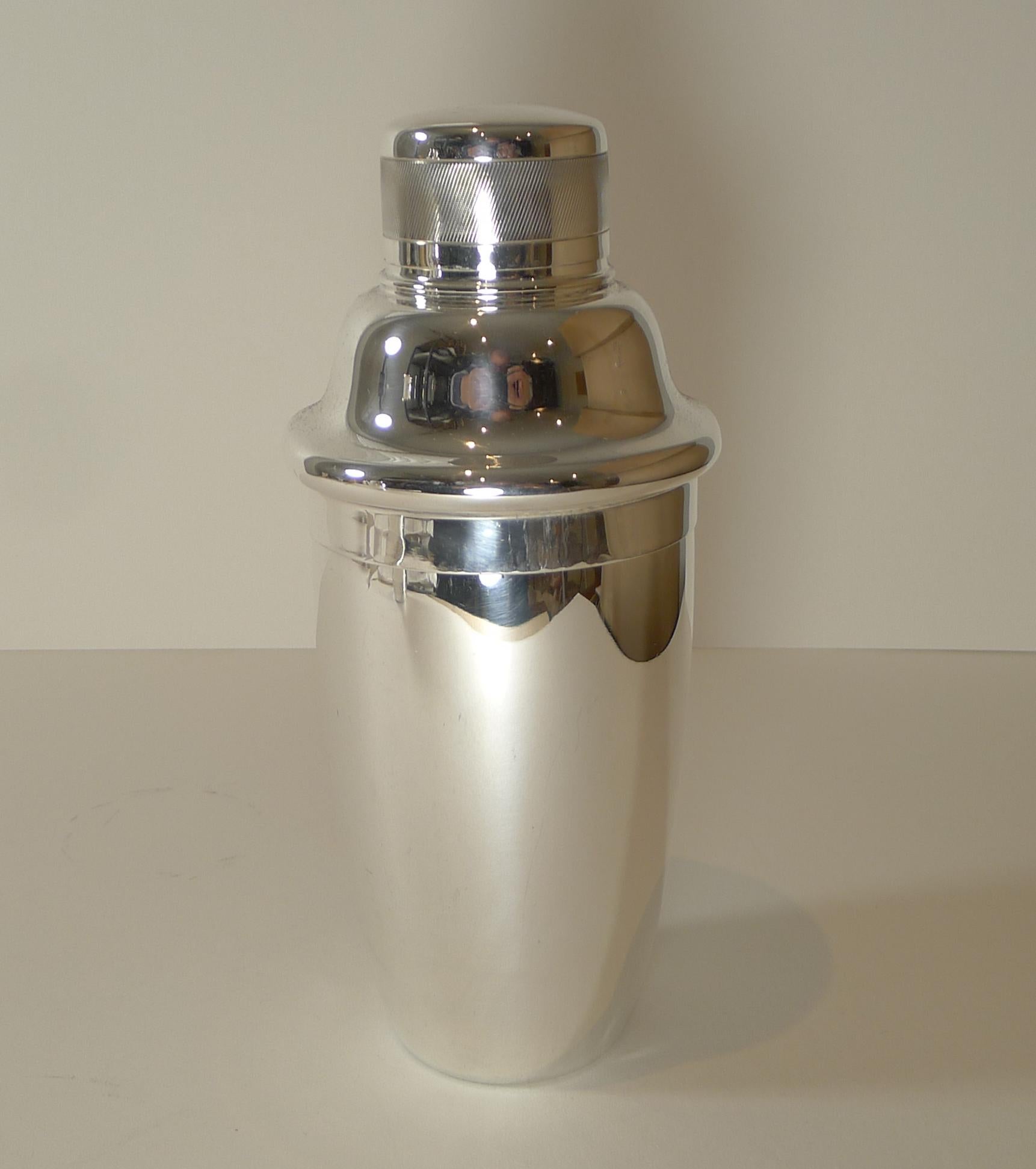 A lovely and unusually shaped cocktail shaker, the top decorated with an engine turned band around the cap.

Just back from our silversmith's workshop where it has been professionally cleaned and polished, restoring to it's former glory.

Art
