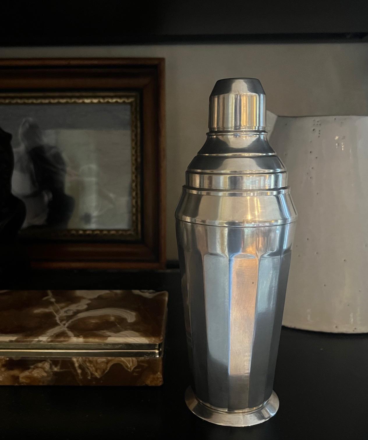 Art Deco cocktail shaker made in France in the 1930's or 1940's. The set includes the main shaker, a strainer and top as well as a makers stamp on the bottom.