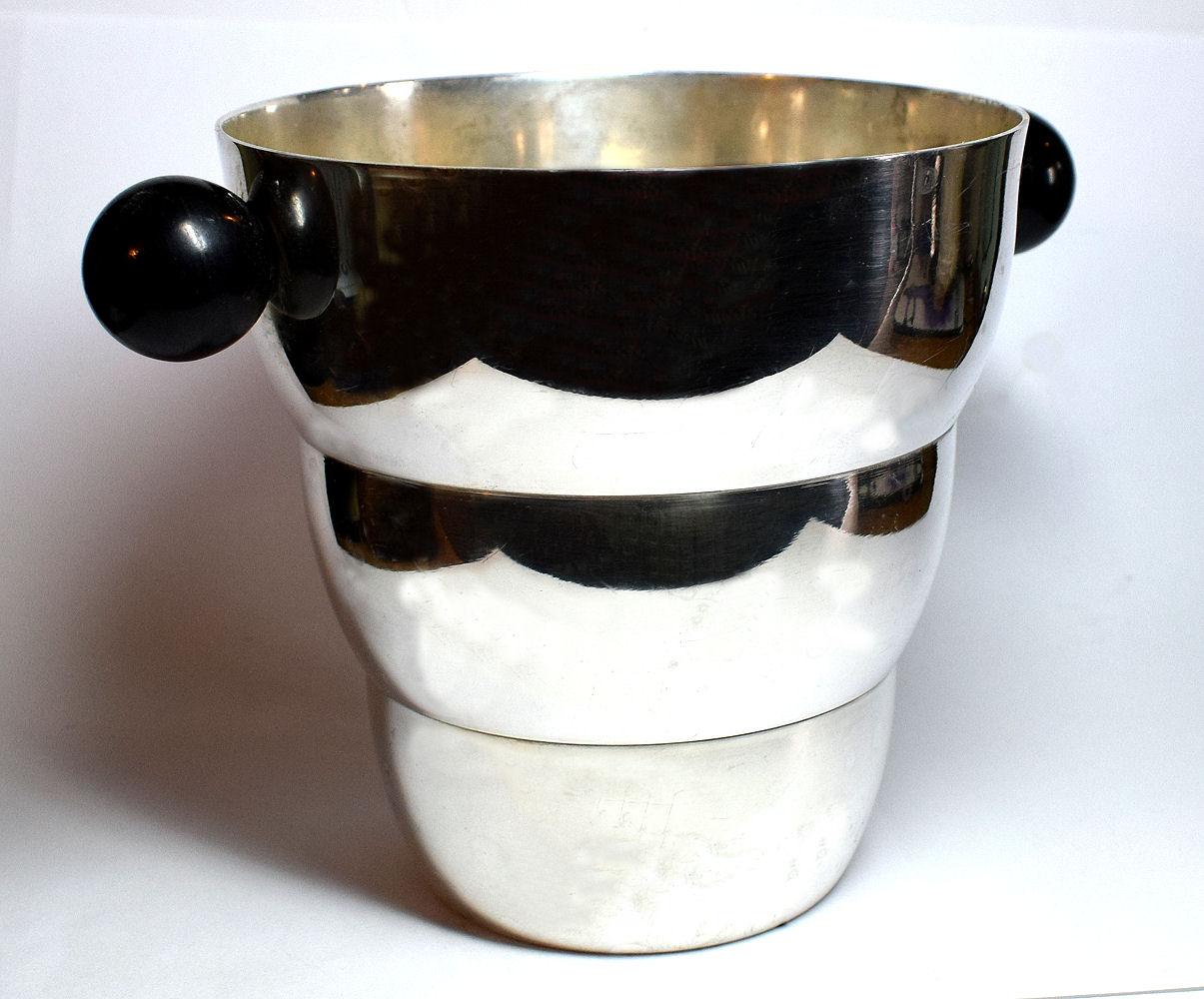 Wonderfully stylish 1930s ice bucket. Silvered plated with black bakelite ball shaped handles this ice bucket has an almost beehive shape and looks great on display. There is some light surface scratches and marks but no dents or dings, altogether