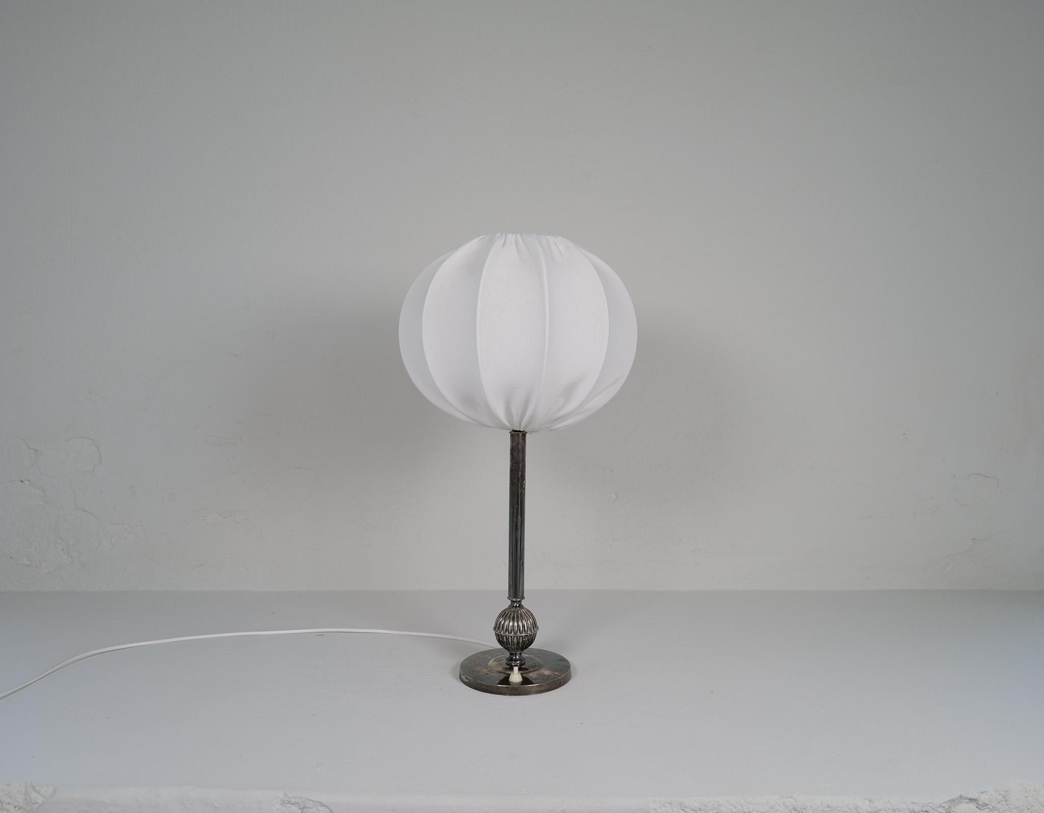 Questa lampada da tavolo argentata è stata realizzata in Svezia nei primi anni Trenta. Lo stile Art Deco combinato con la grazia svedese conferisce a questa lampada un aspetto piacevole. Realizzato per A.I.C. Hallberg Svezia.

La lampada è