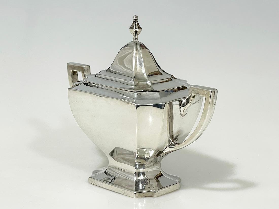 Azucarero de plata Art Déco de Sterling Silver Mfg. Co., Saart Bros., 1920

Azucarero Art Déco de plata de ley con dos asas, de Sterling Silver Mfg. Co.
1908-1932. Fabricantes de cubiertos de esterlina, cucharas huecas y cucharas de recuerdo. Esta