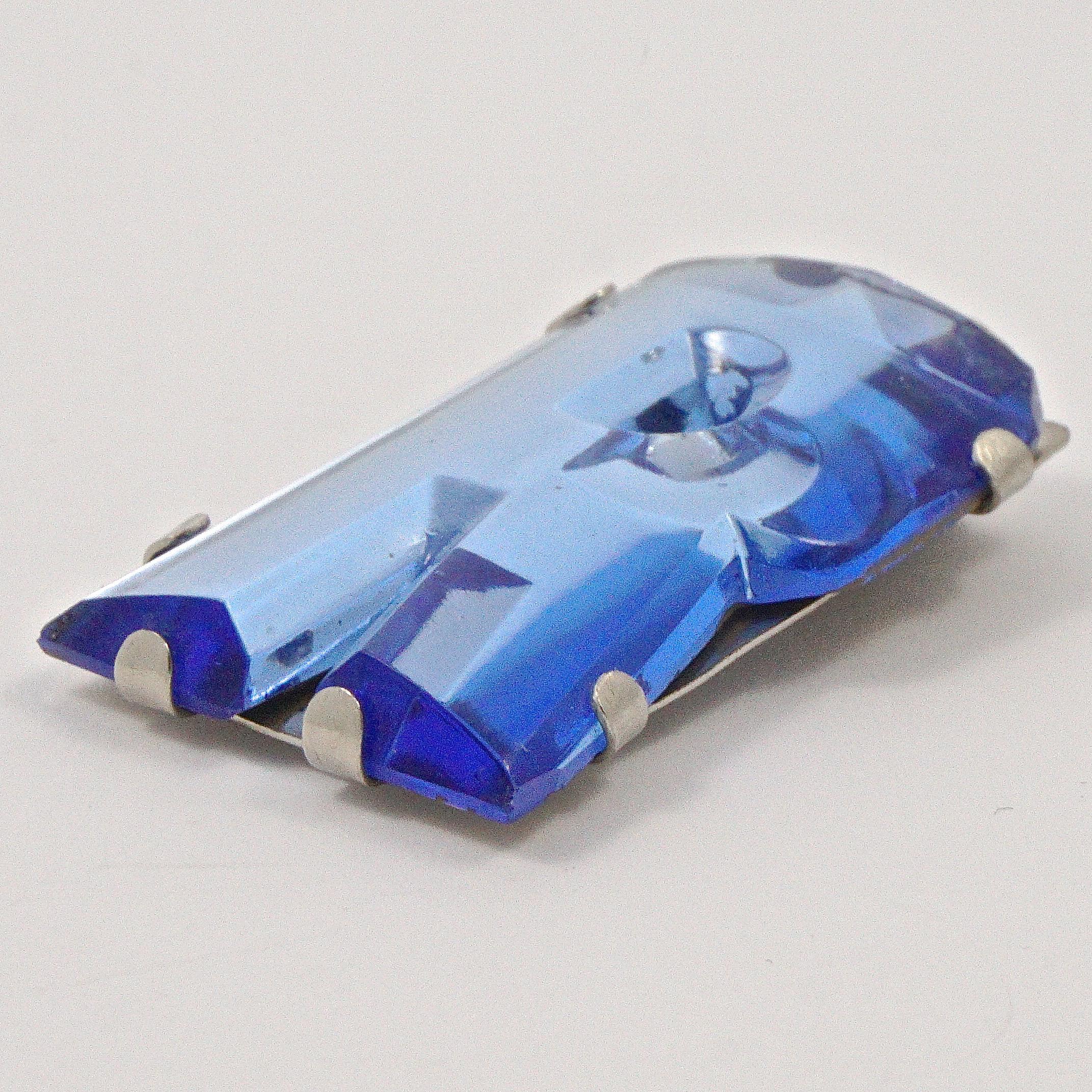 Pince à robe Art Déco en verre bleu miroir avec initiales R dans une monture en argent. La partie supérieure est facettée. Longueur de 4 cm / 1,57 pouces et largeur maximale de 2,3 cm / 0,9 pouce.  Le clip de la robe est en très bon état, il y a