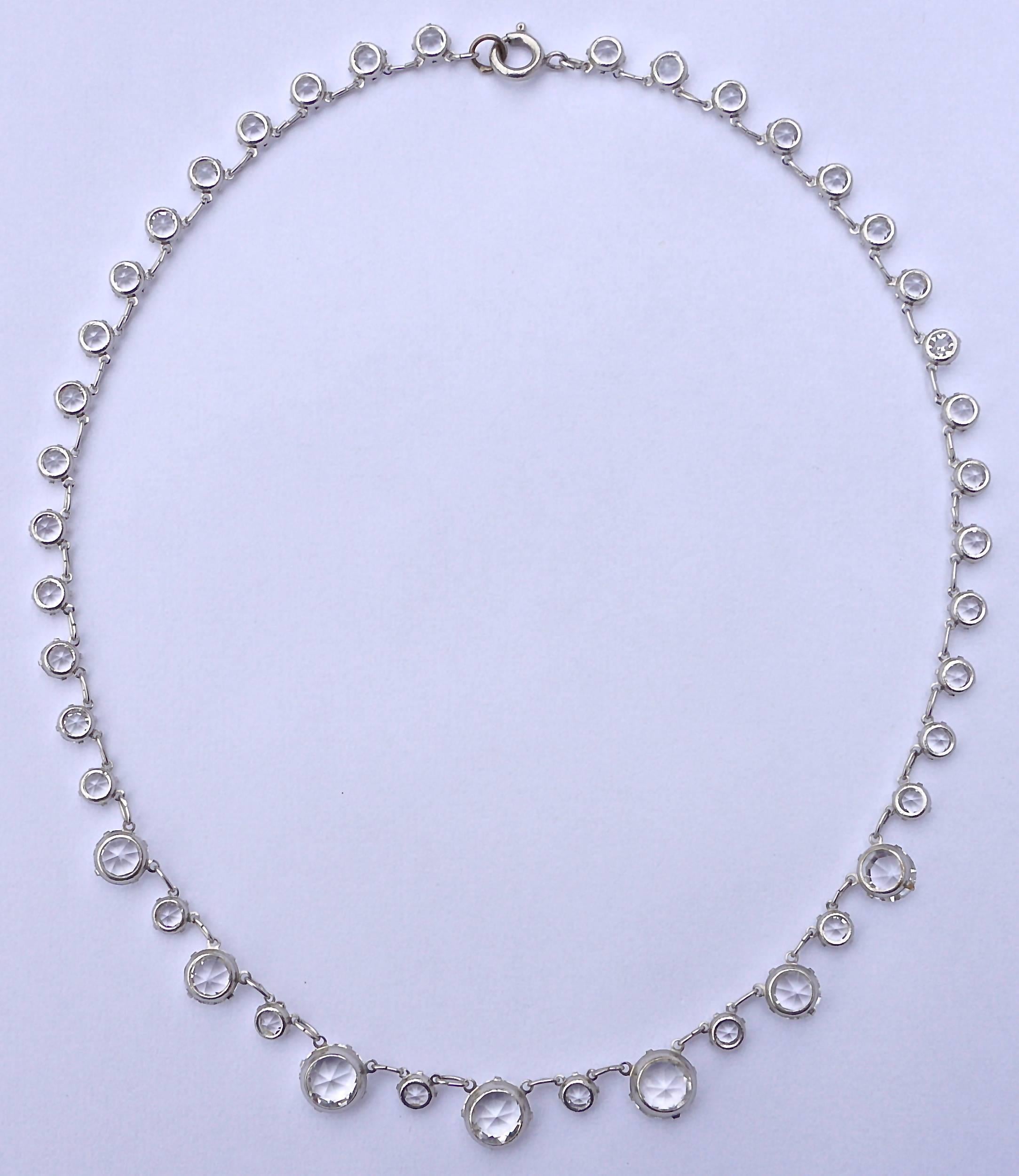 Silver tone Art Deco necklace with beautiful clear crystals in open back settings, and a spring bolt clasp. The faceted crystals are dome shaped at the front and pointed at the back, for maximum sparkle. Length 39cm / 15.3 inches. The smallest