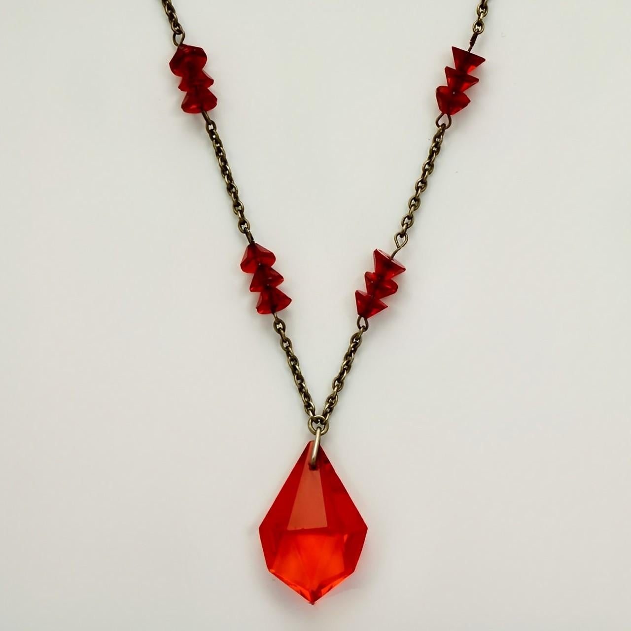 Art Deco silver tone chain necklace featuring red glass crystal beads, and a lovely drop pendant. The pendant is an orange red colour. The chain links are soldered. Length 45.5 cm / 17.9 inches, and the pendant length is 2.3 cm / .9 inch.

This is a