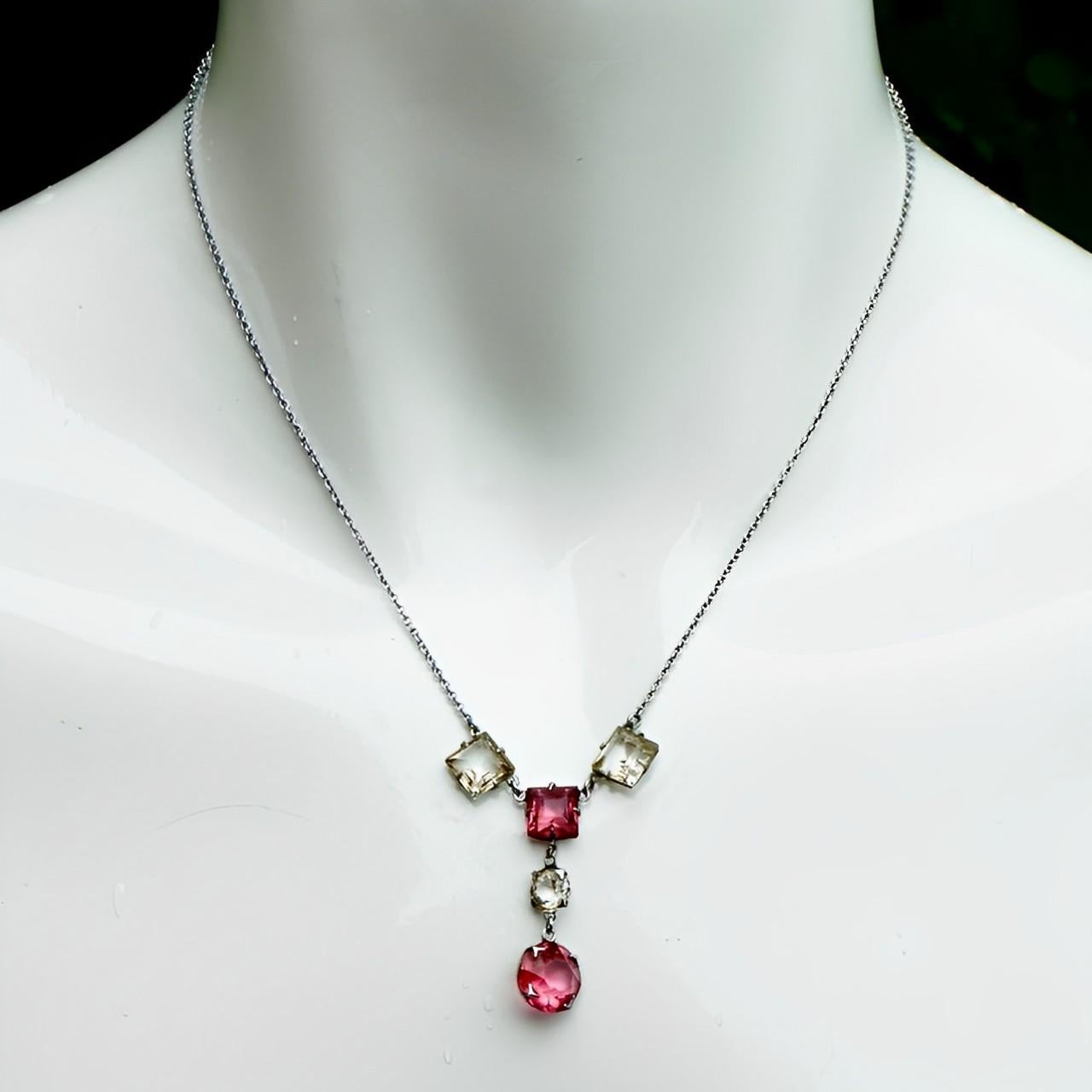 Art Deco silver tone chain necklace featuring a lovely drop pendant with square rouge pink and clear glass crystals in open back settings. The faceted crystals are raised at the front and pointed at the back, for maximum sparkle. The chain links are