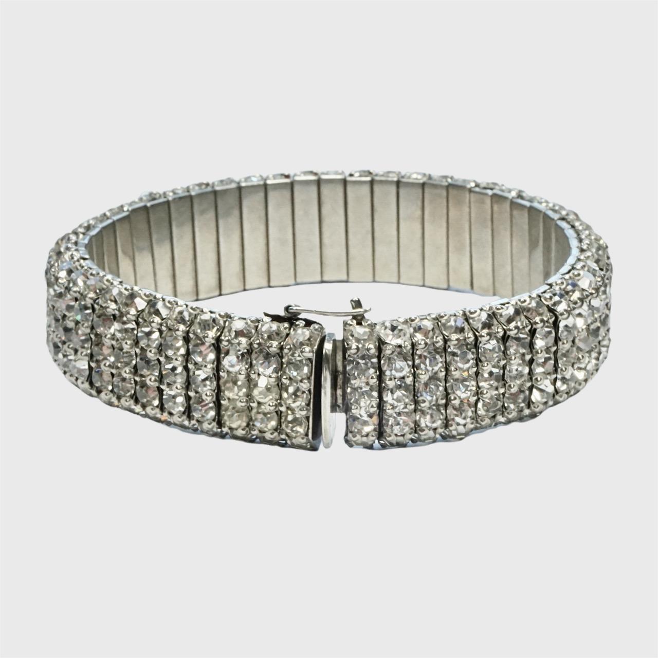 
Elegante bracciale a maglie in stile Art Deco in tonalità argento, con strass incastonati e clip di sicurezza. Ogni anello è composto da cinque strass. La chiusura funziona bene. Lunghezza 18,3 cm / 7,2 pollici e larghezza 1,4 cm / .55 pollici. Uno