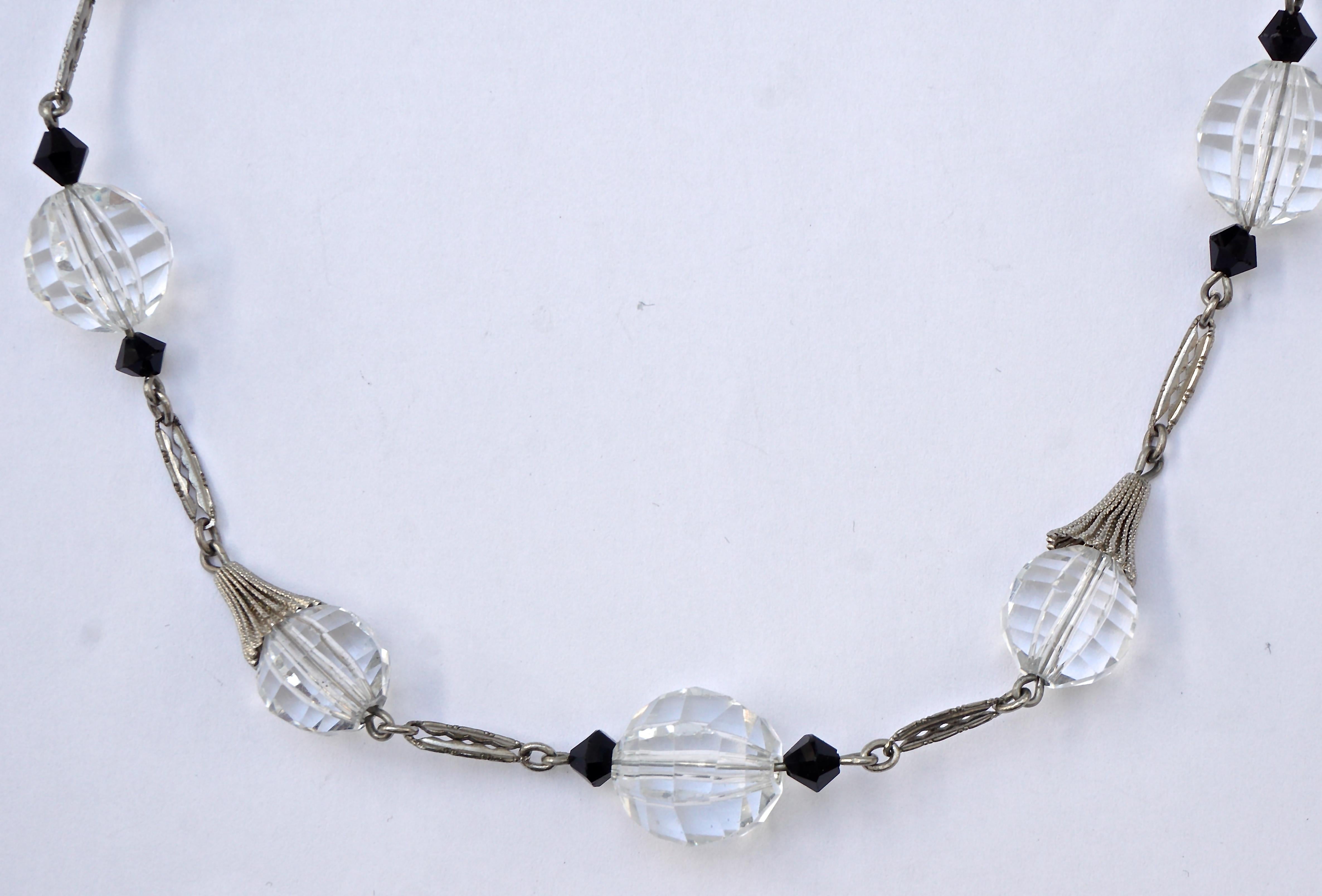 
Beautiful Art Deco necklace with black and clear faceted glass beads and a barrel clasp, circa 1930s, and length 43.8cm / 17.24 inches. The silver tone metal links have a typical Art Deco design. The centre clear glass stone is 1.45cm / .57 inch