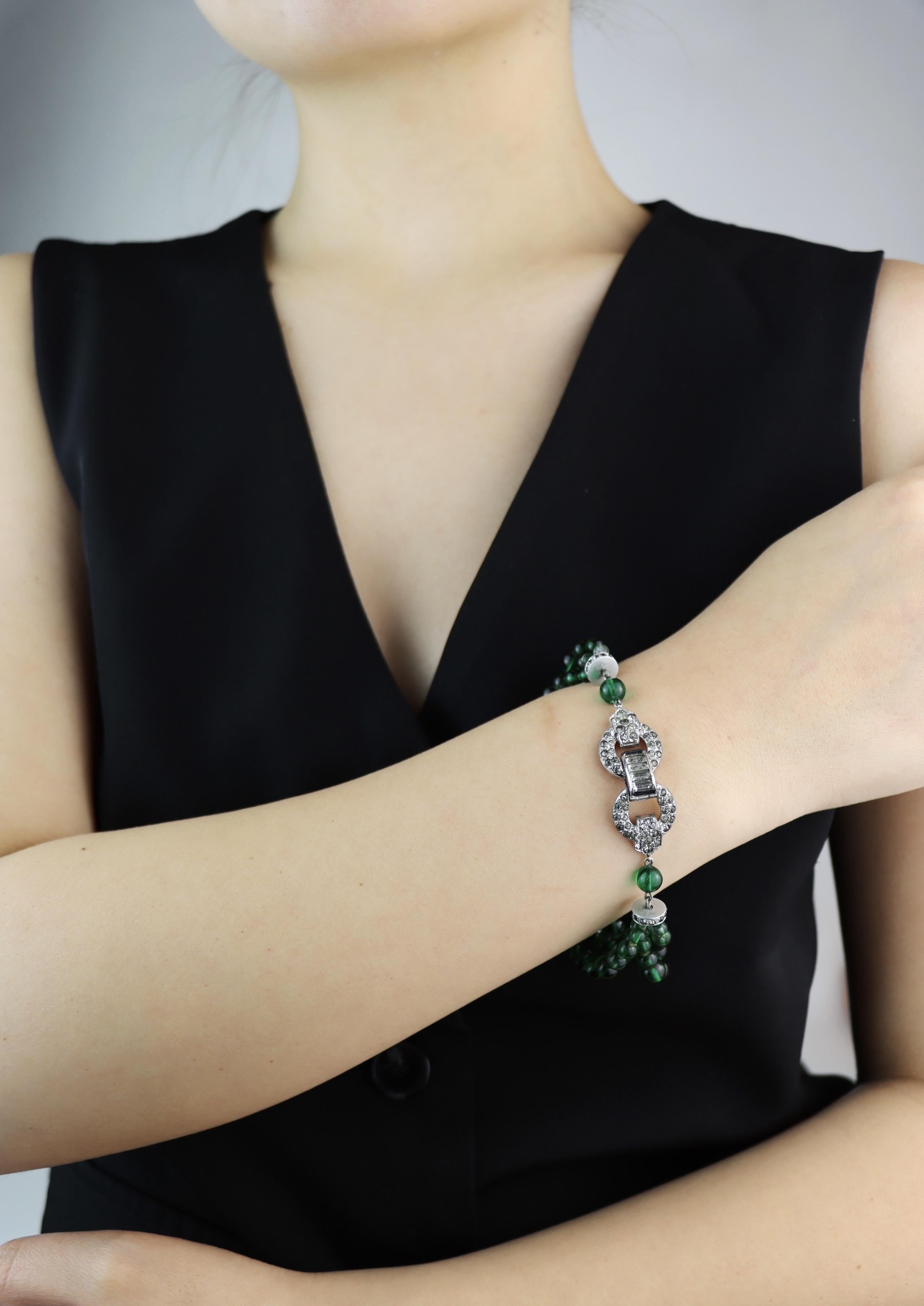 Art Deco Silver Tone Rhinestone Muti-Stand Green Beads Bracelet

﻿﻿Approximate Dimensions:
20.2 (circumference)
1.5 cm -2.4 cm (Width)
36.6 grams in weight.