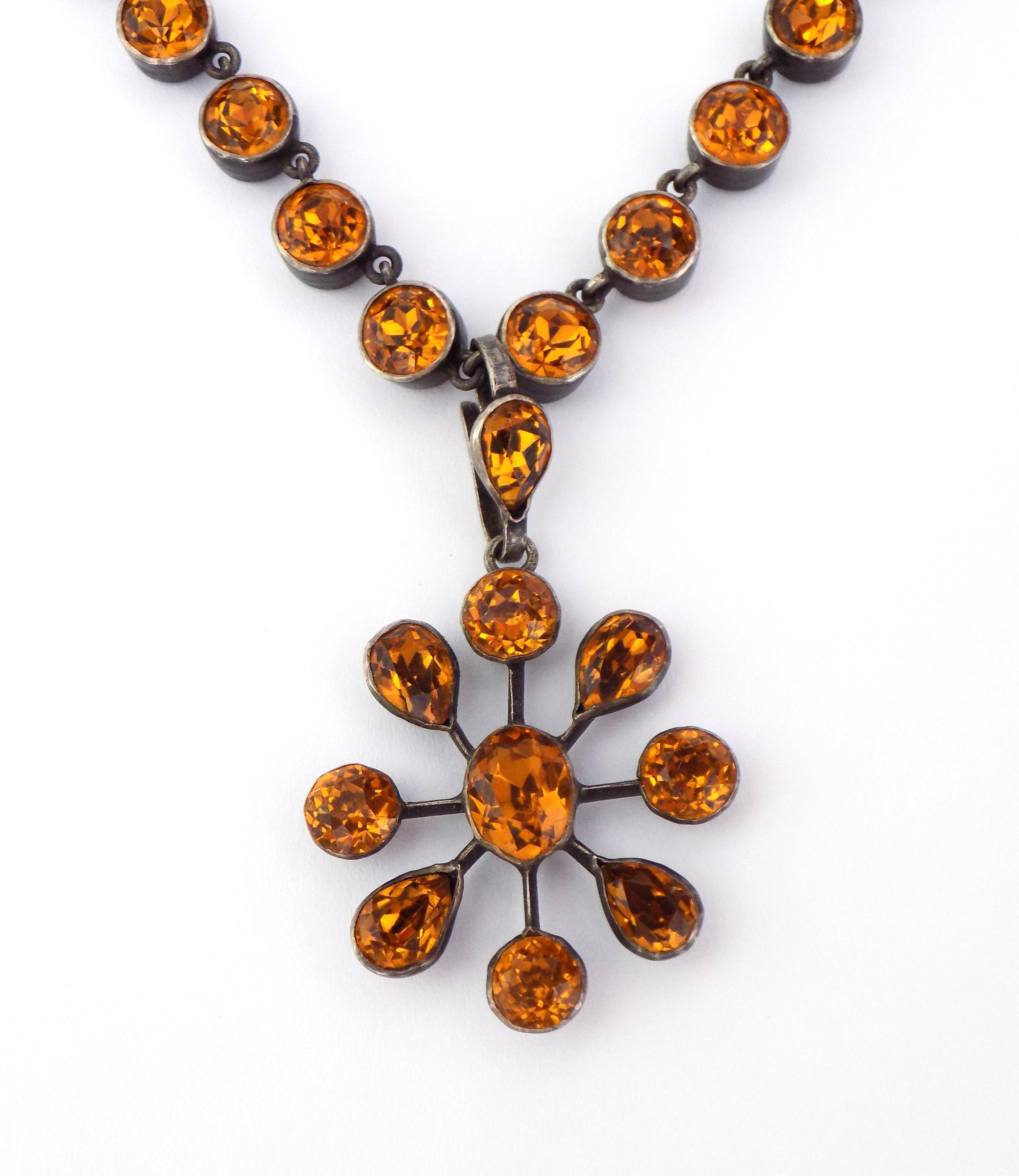 A Stunning Art Deco c. 1920s Silver and Yellow Topaz colour paste (glass) necklace with attached pendant and can be easily removed. The paste stones in closed back setting, the necklace well made. An eye-catching piece of jewellery. Continental
