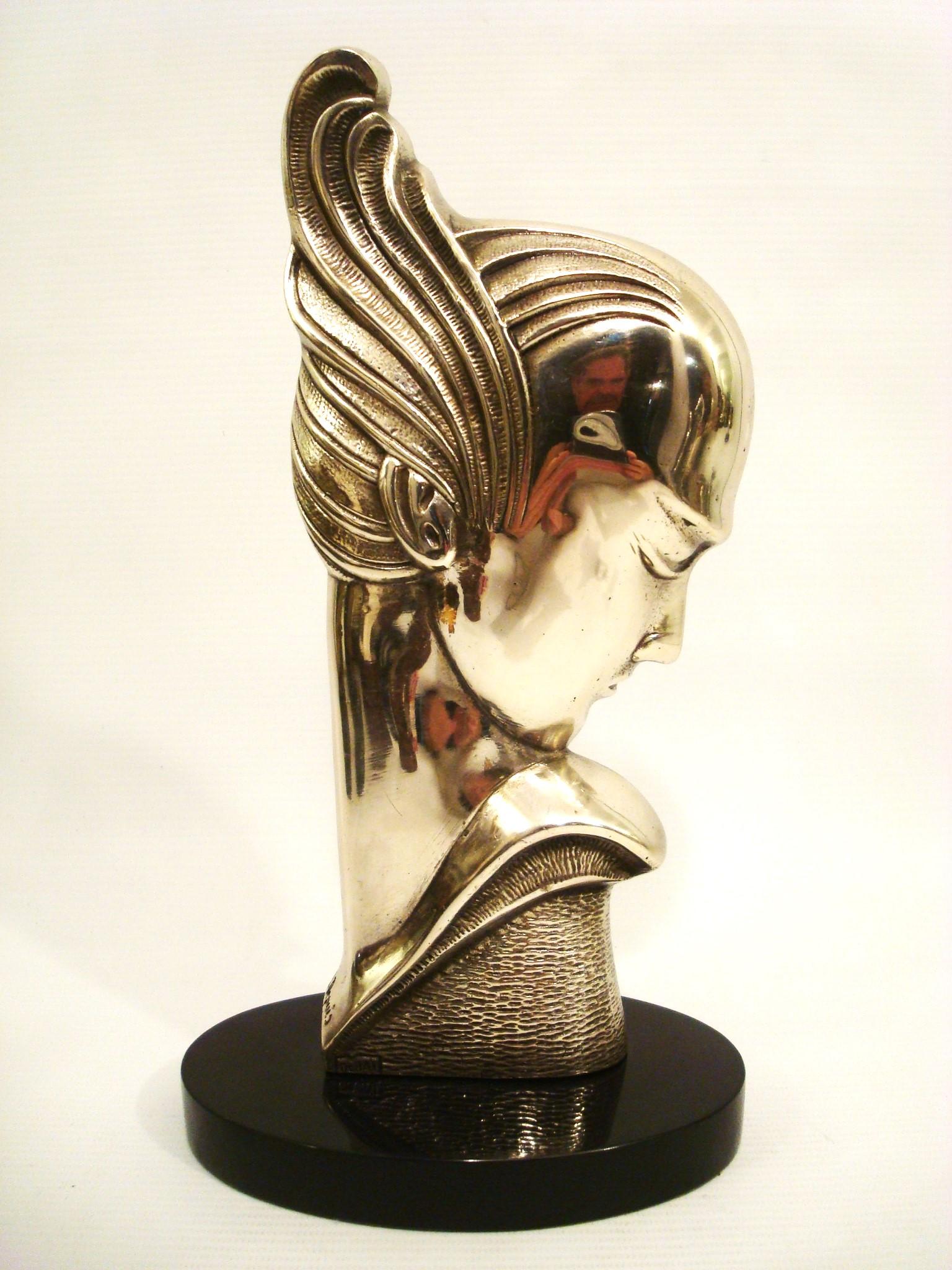 Escultura Art Decó de busto de mujer en bronce plateado / Francia, 1930
Escultura Art decó de bronce plateado de una cabeza humana estilizada, montada sobre una base ovalada de mármol negro. La cabeza está inclinada hacia abajo, y el pelo está