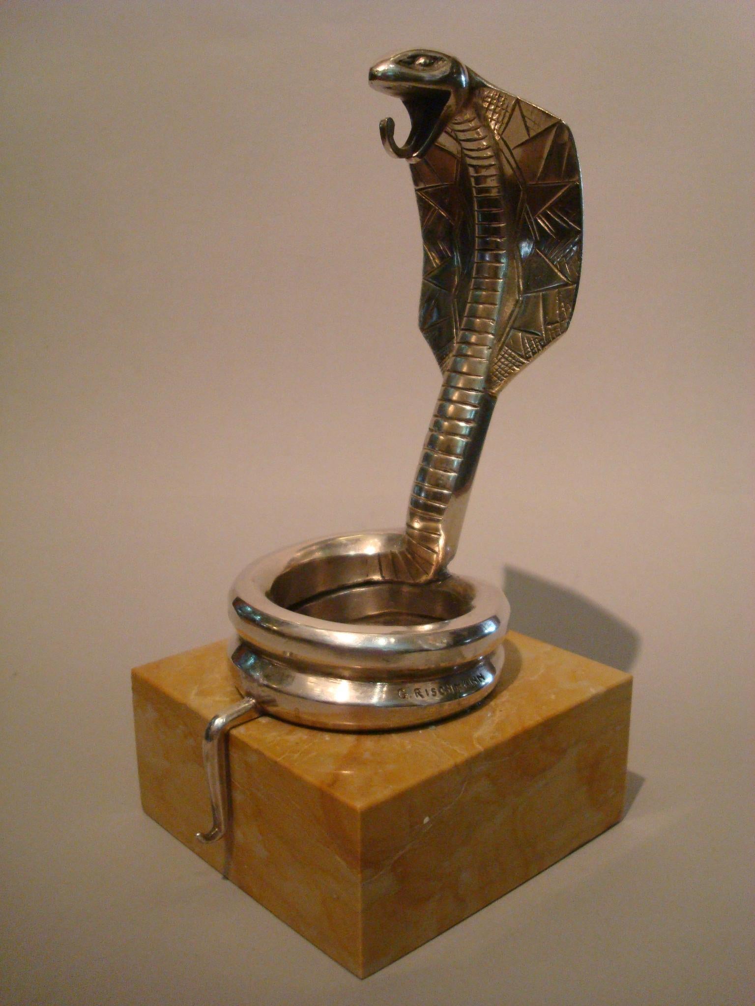 Art Deco versilberte Bronze Kobra Auto Maskottchen / Hood Ornament / Briefbeschwerer oder Uhrenständer von Rischmann, Frankreich, 1920er Jahre.
Versilberte Bronzeskulptur einer Kobra, montiert auf einem hellbraunen Marmorsockel. Unterschrieben: G.