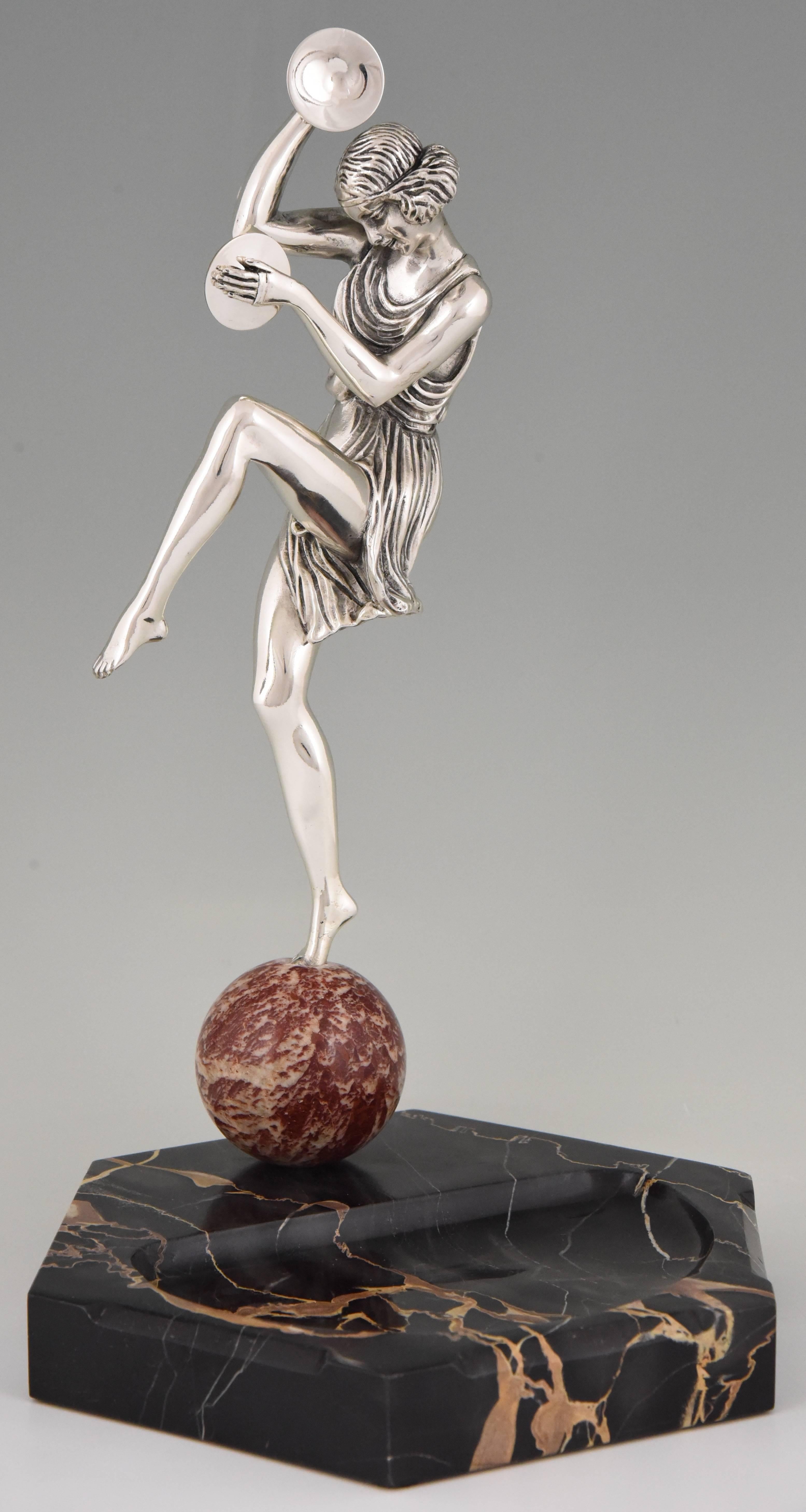 Art Deco silvered bronze cymbal dancer on a red marble ball mounted on a Portor marble tray signed by the well know French sculptor Pierre Le Faguays.
     