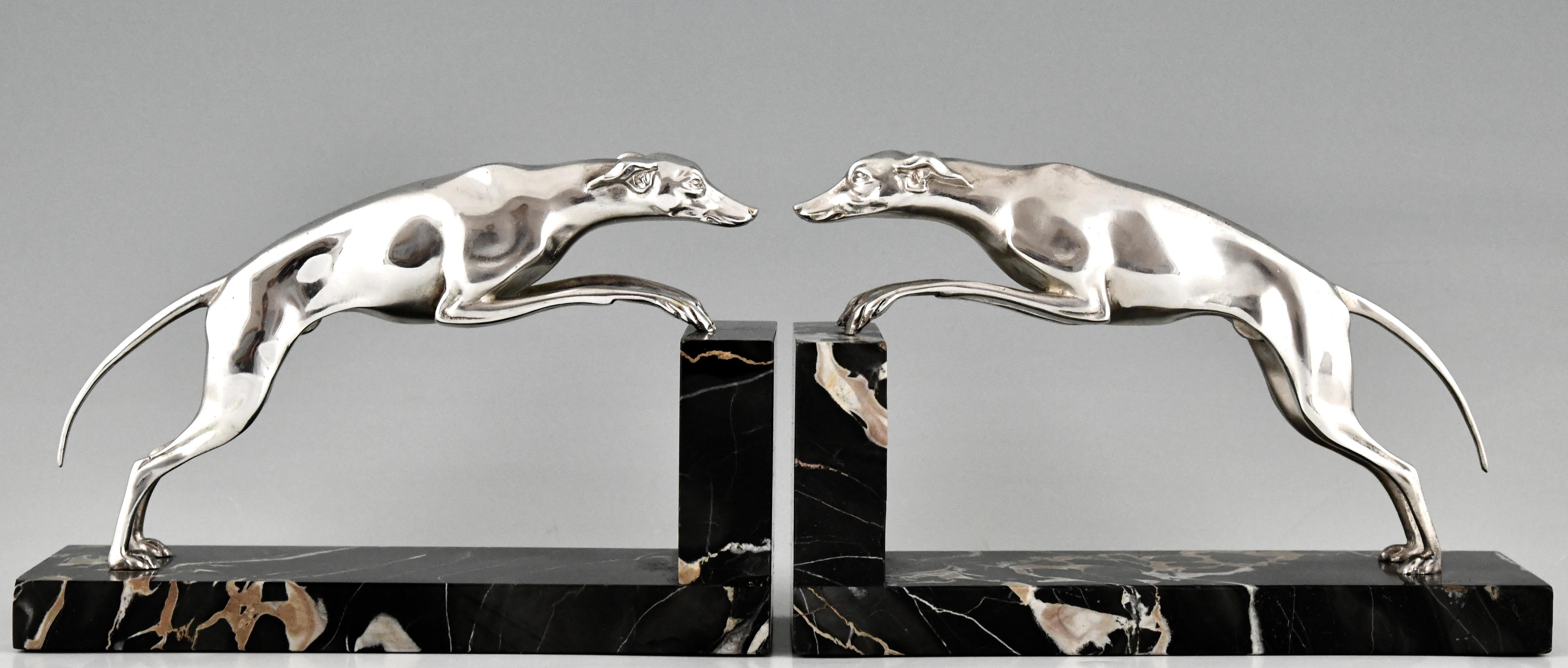 Elegant pair of silvered bronze Art Deco bookends with leaping greyhounds. Signed by Gerorges Gori, France ca. 1930.
The dogs are mounted on Portor marble bases. 
Literature:
Benezit. ?Statuettes of the Art Deco period.